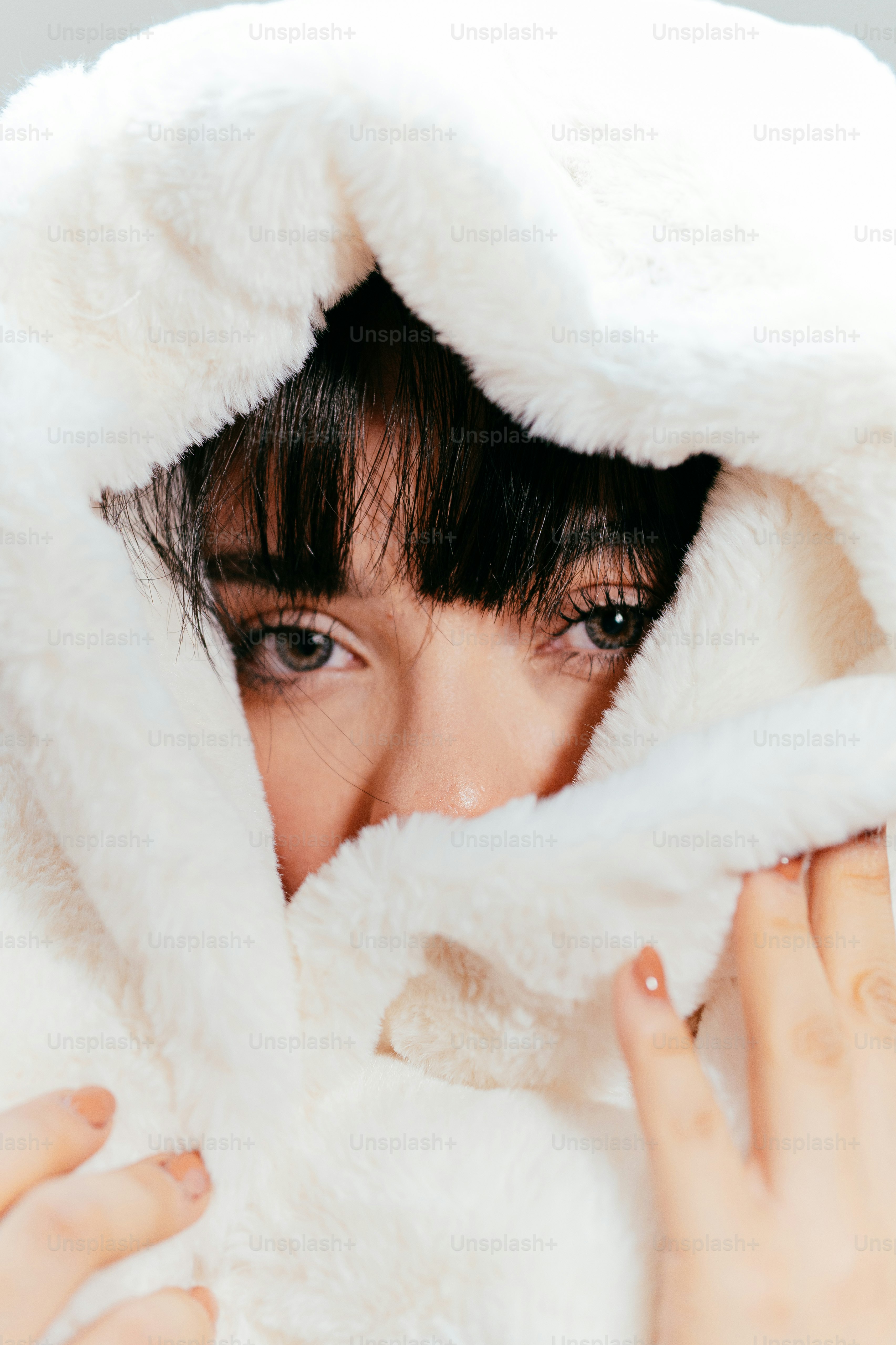 Woman peeking through fluffy white hood