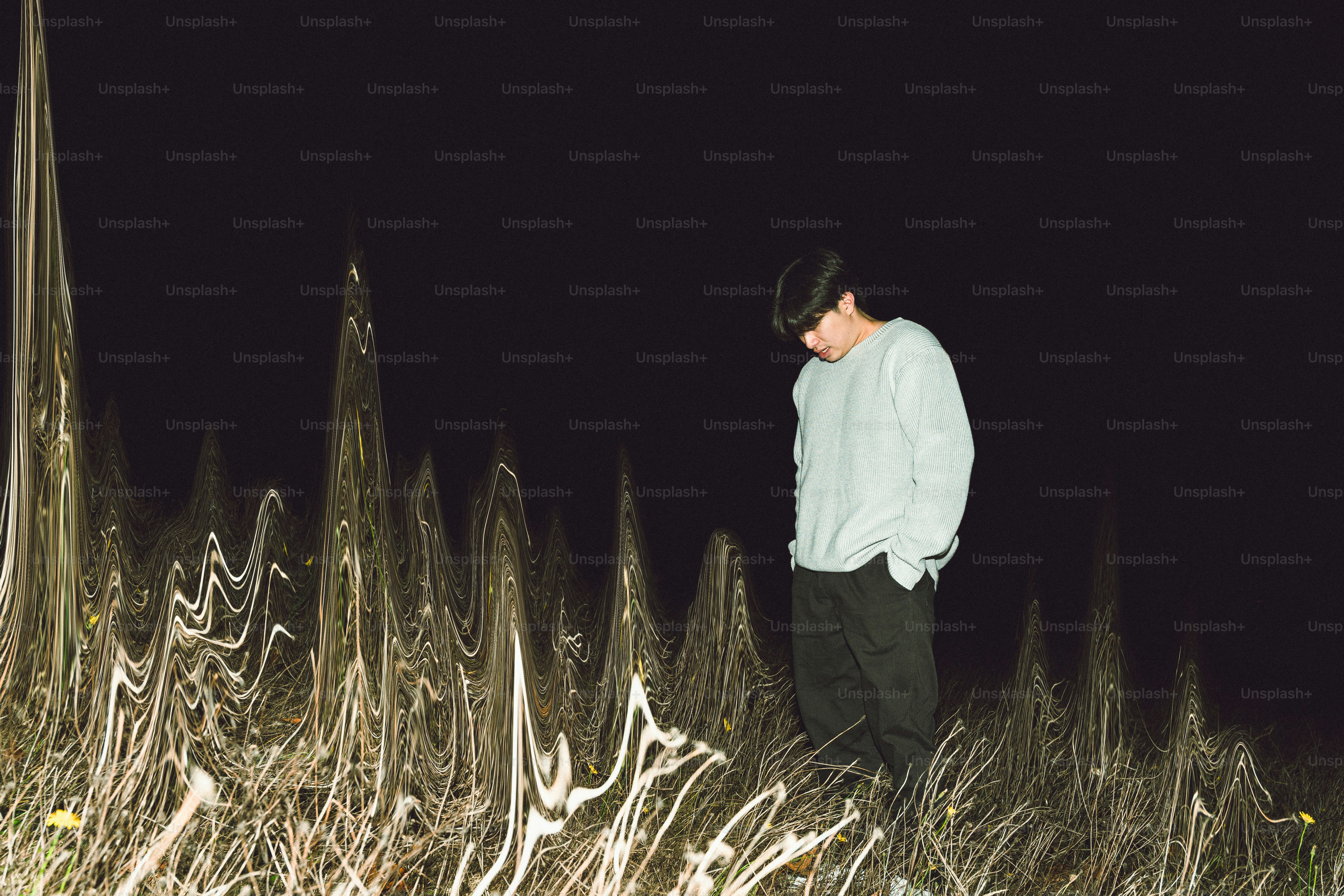 Man standing in tall grass at night