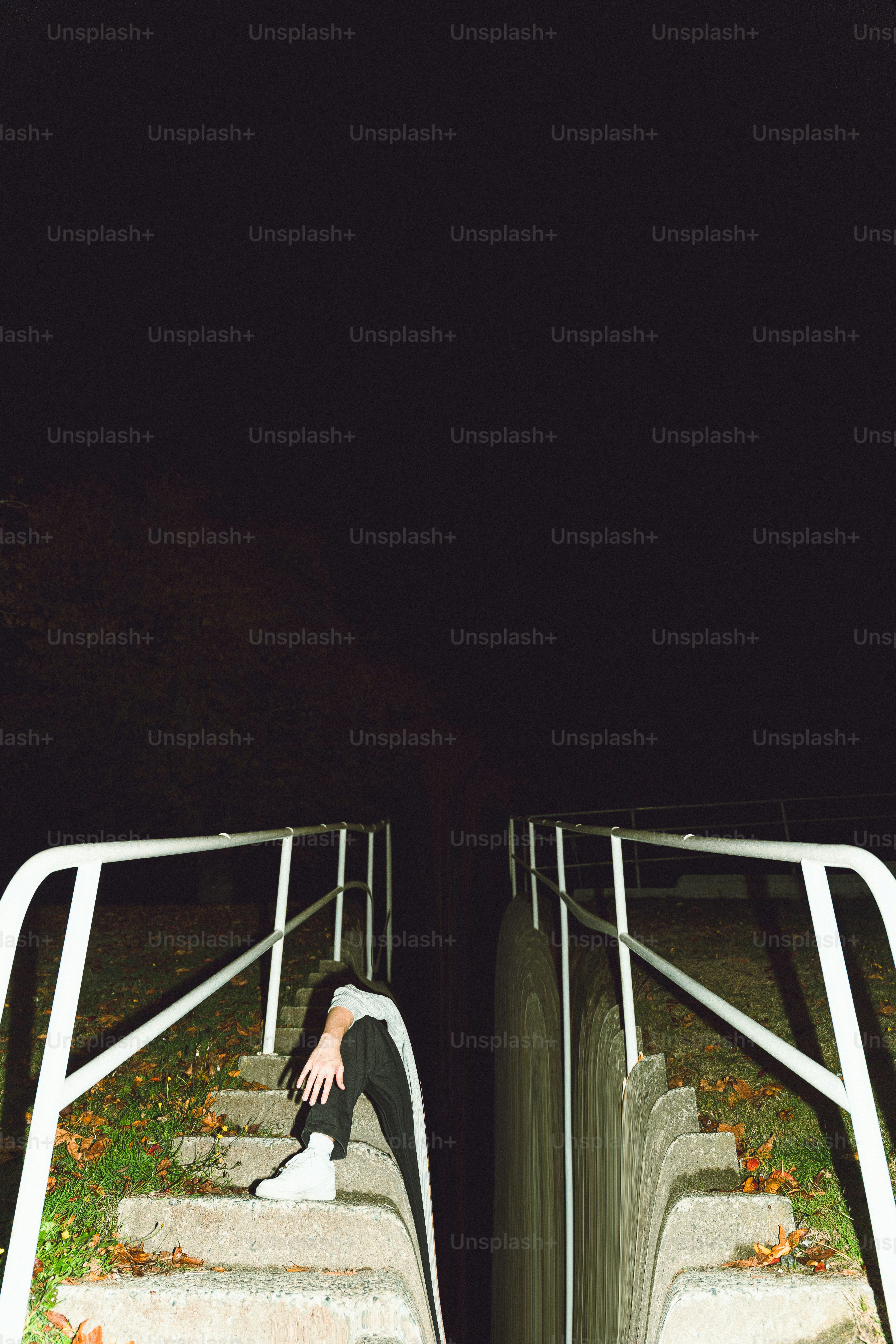 Person sitting alone on stairs at night.