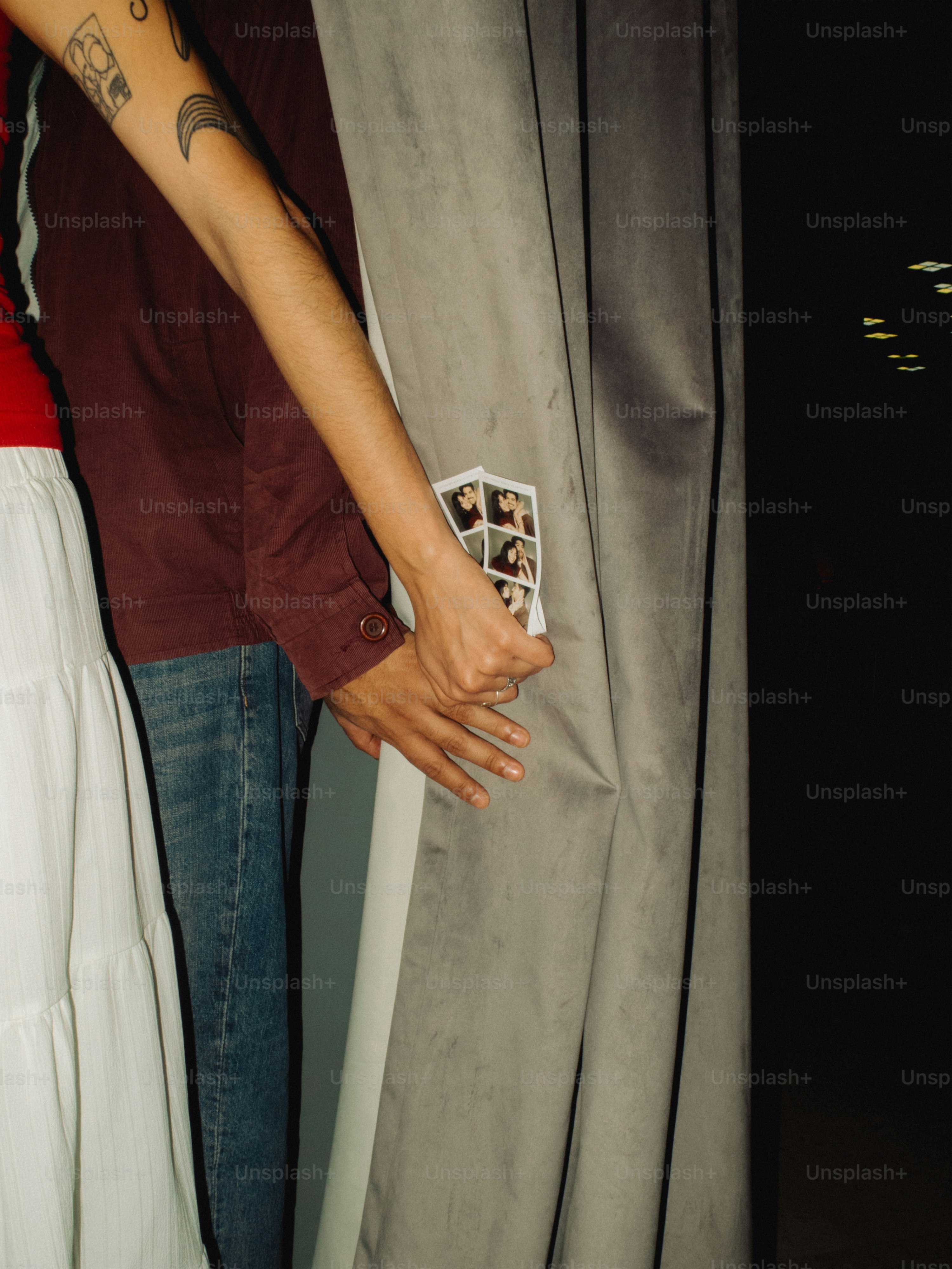 Couple holding hands with photo booth strip