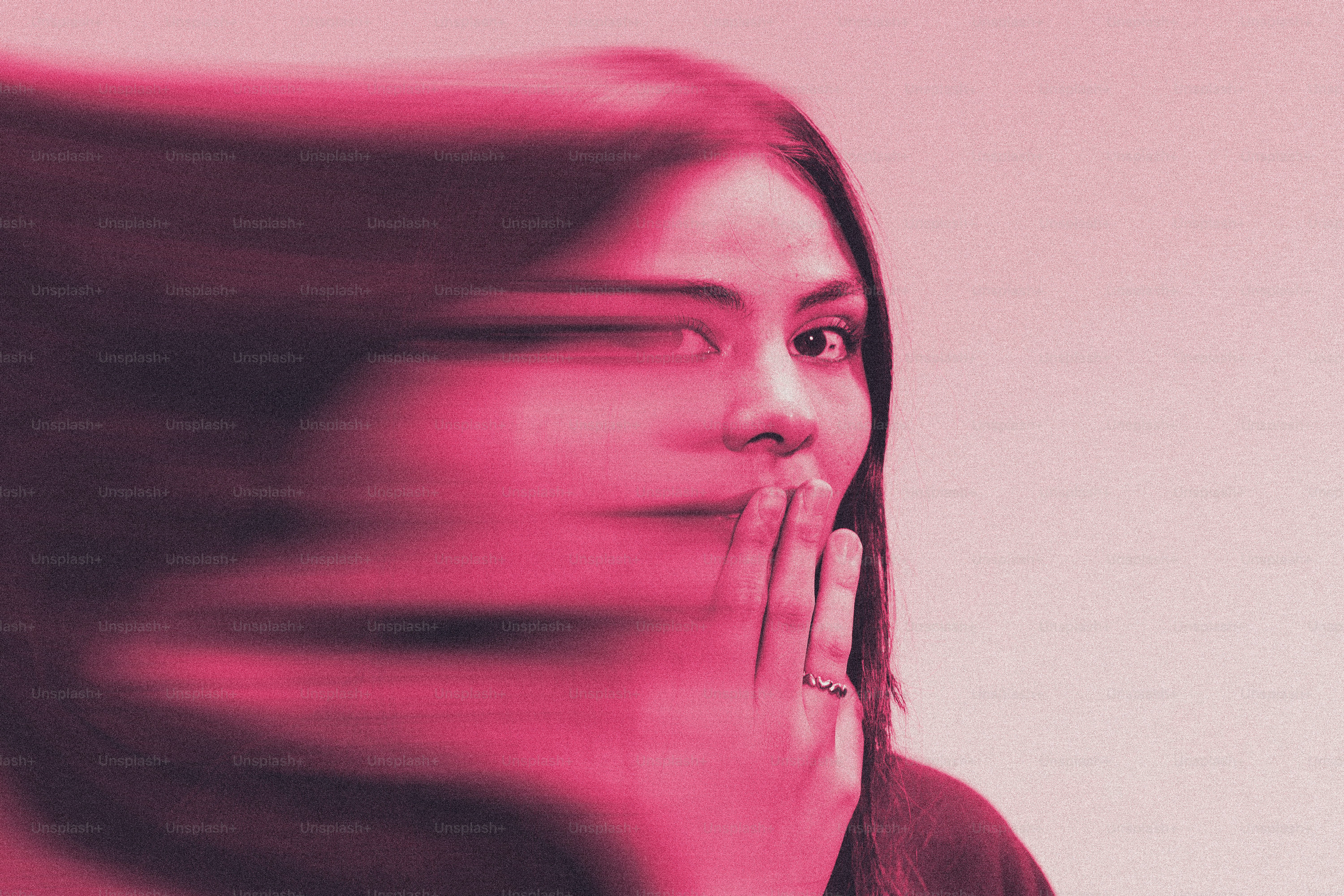 Woman with hand over mouth, hair blurred