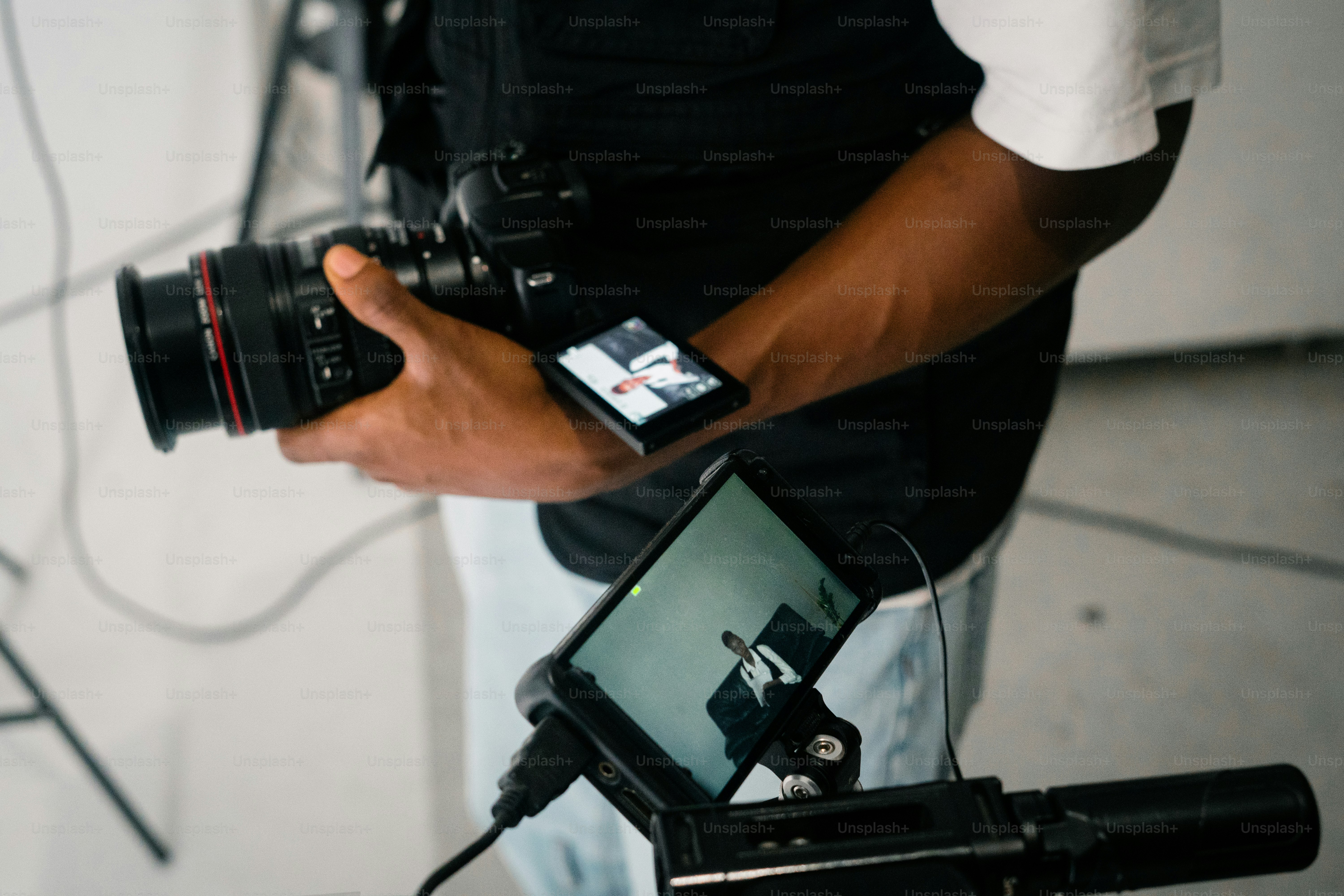Person holding camera with monitor attachment