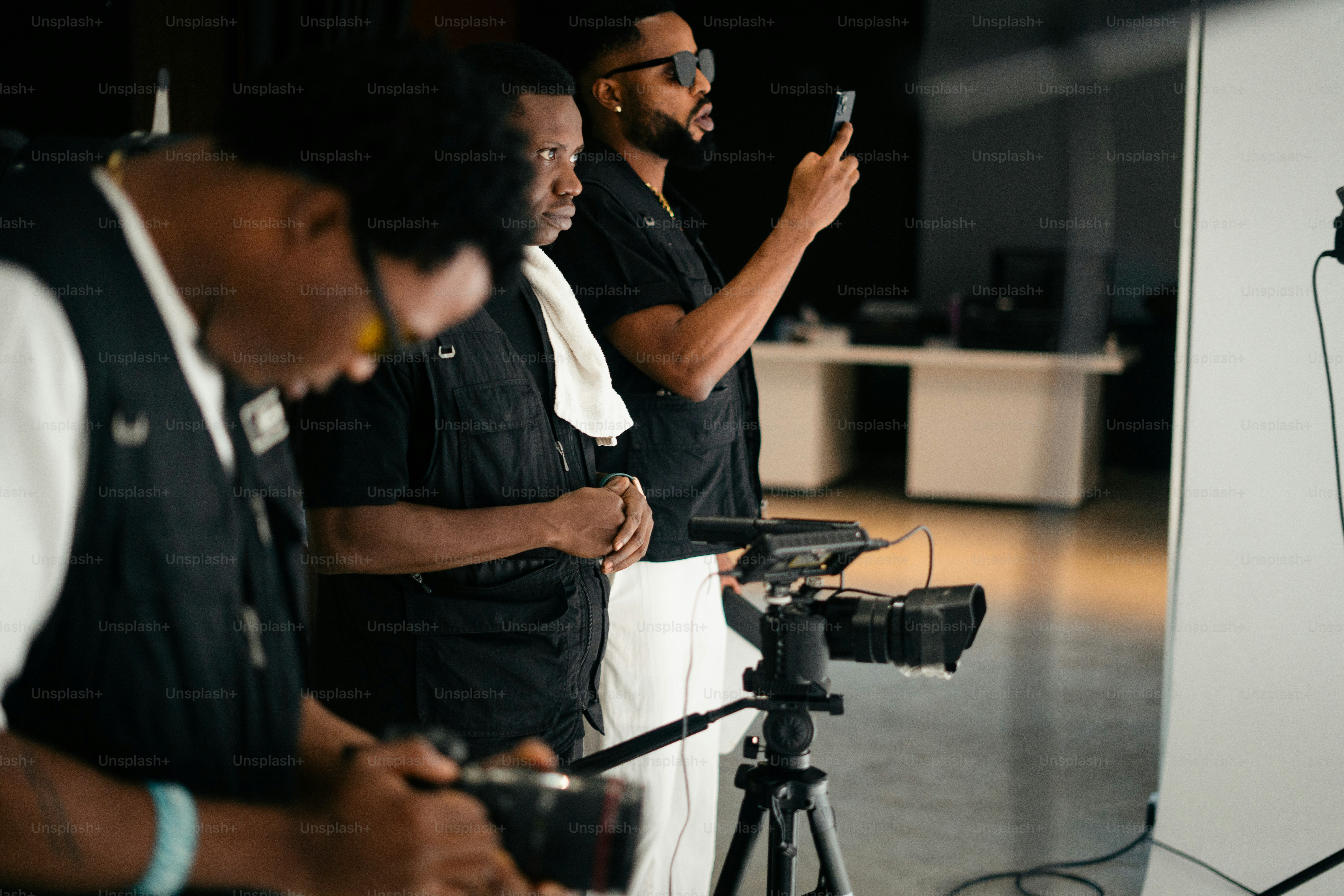 Three men in a studio with camera equipment