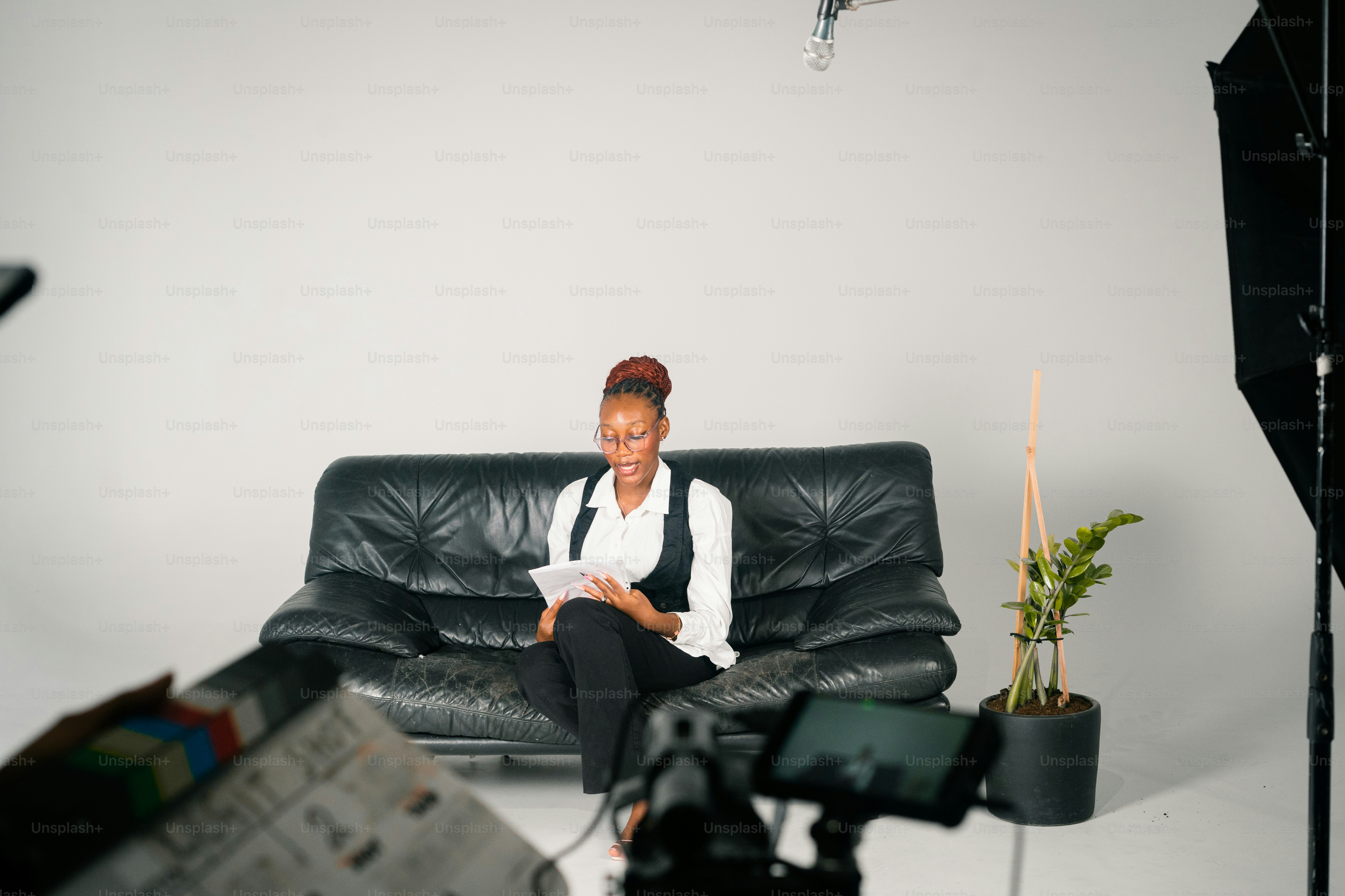A woman sits on a black couch reading