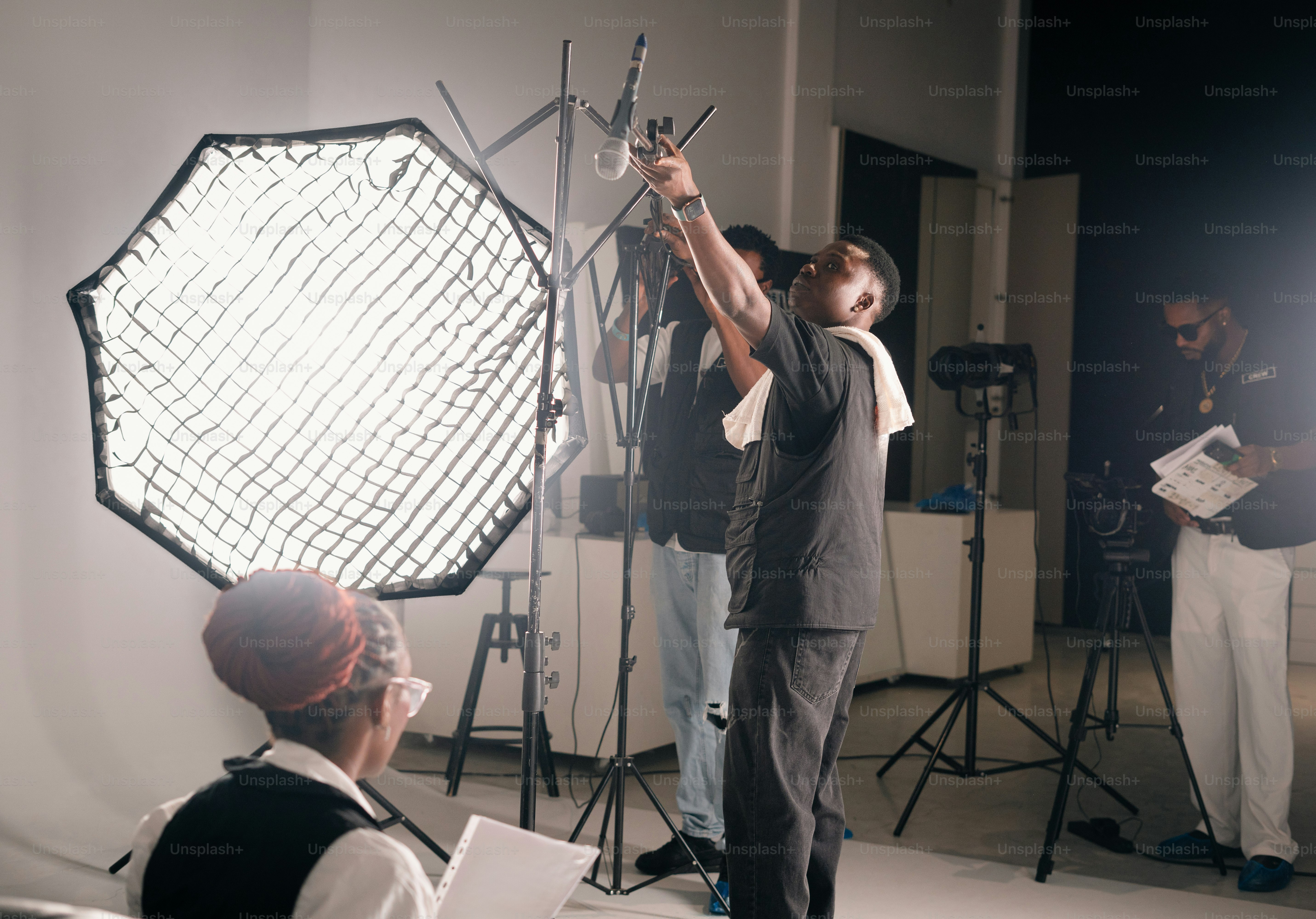 People setting up studio lights for a photoshoot.