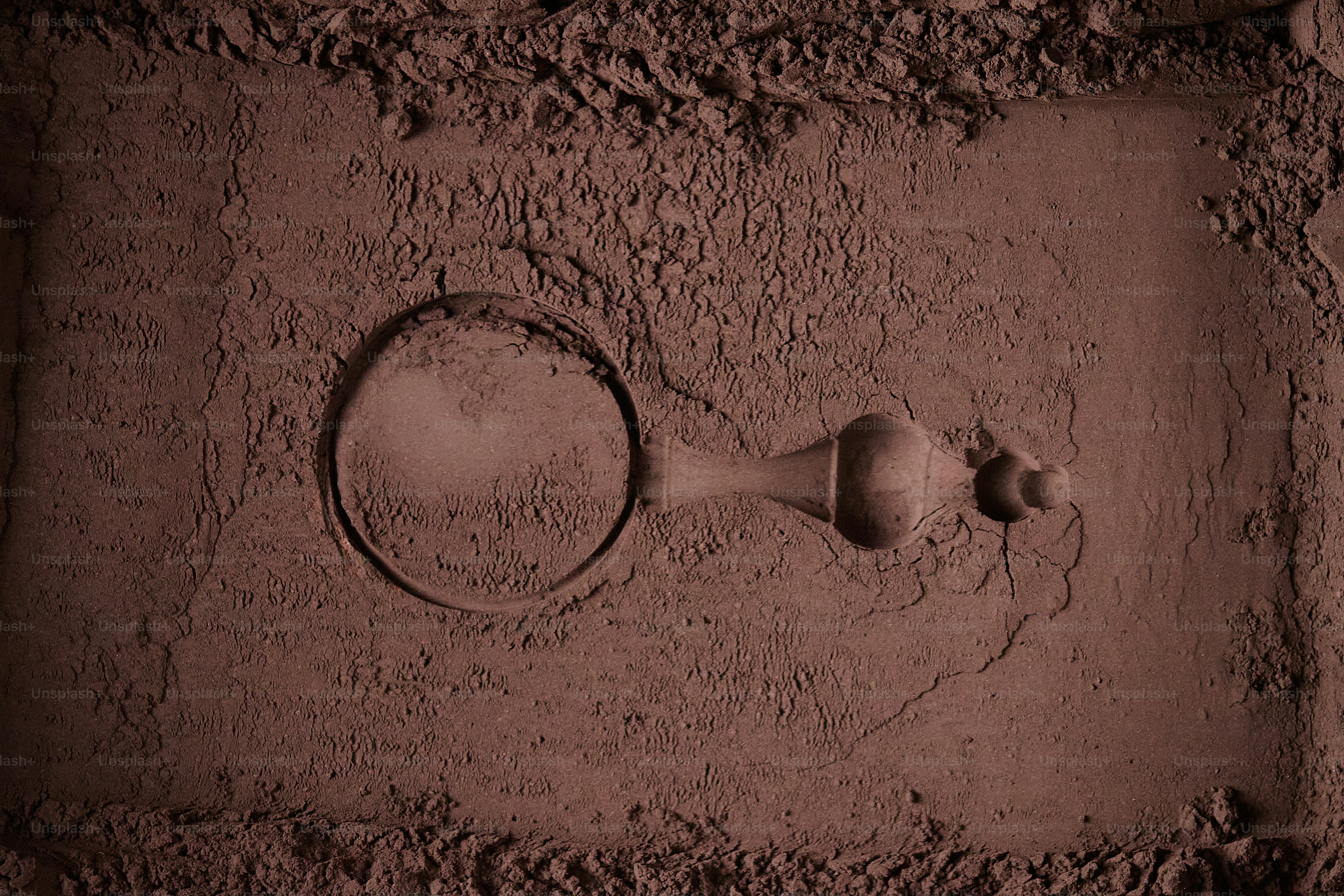 A scoop lies in a pile of cocoa powder
