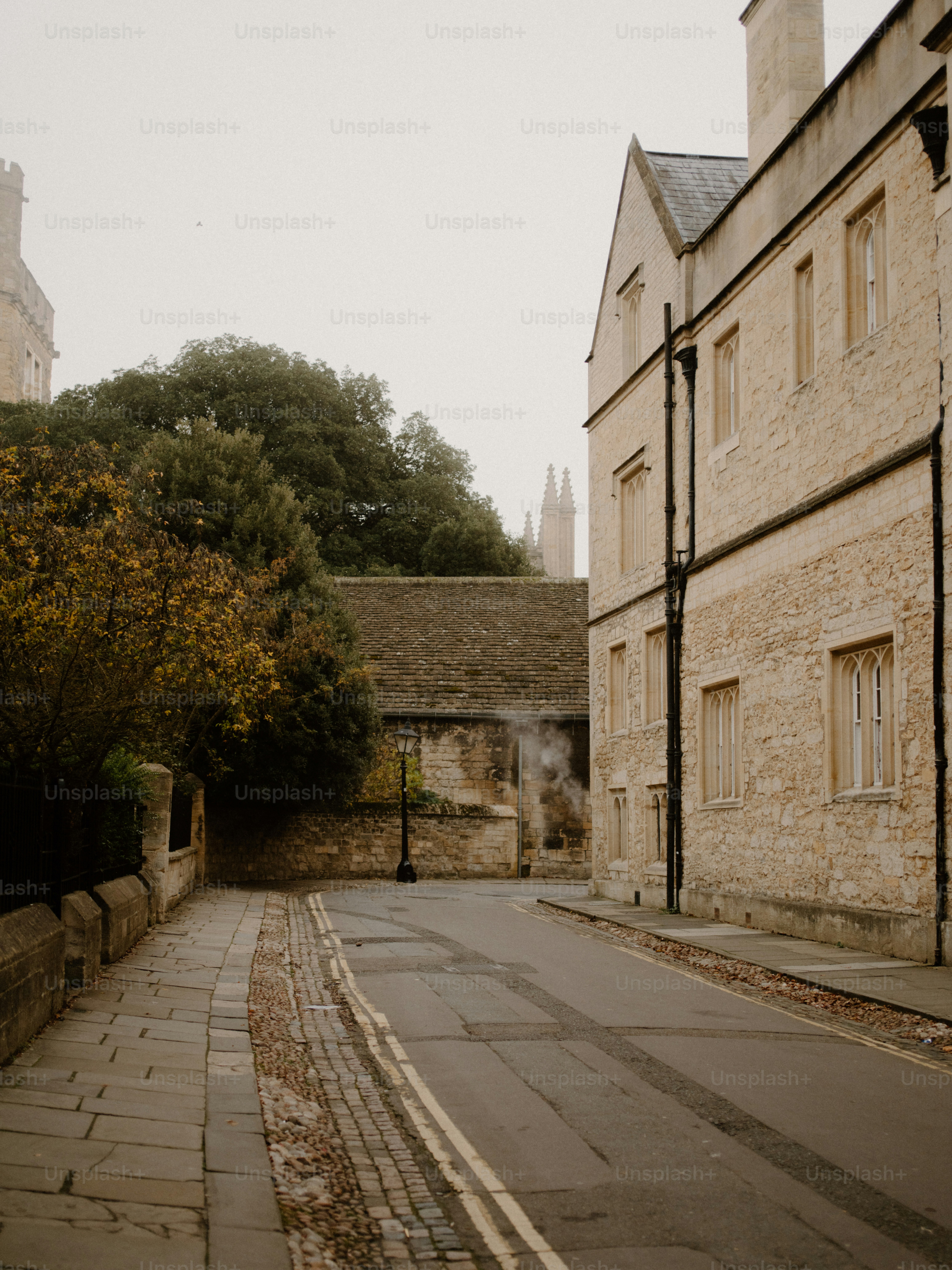 Historic stone buildings line a quiet cobblestone street.