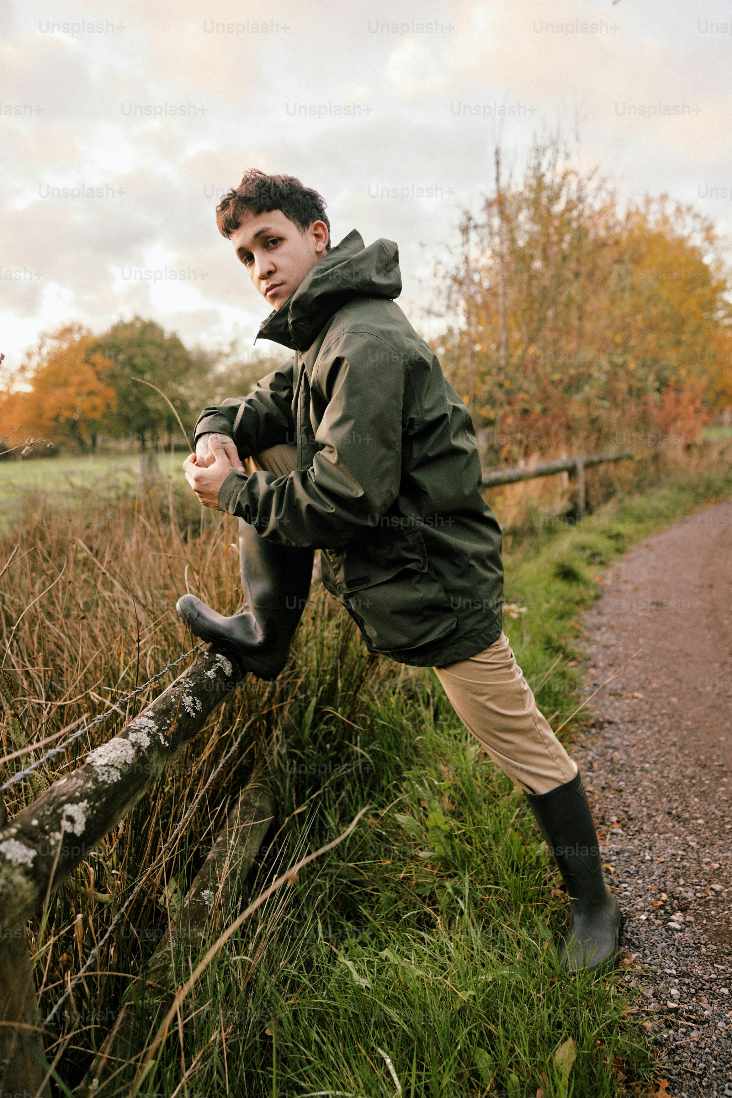 Junger Mann in grüner Jacke und Stiefeln im Freien