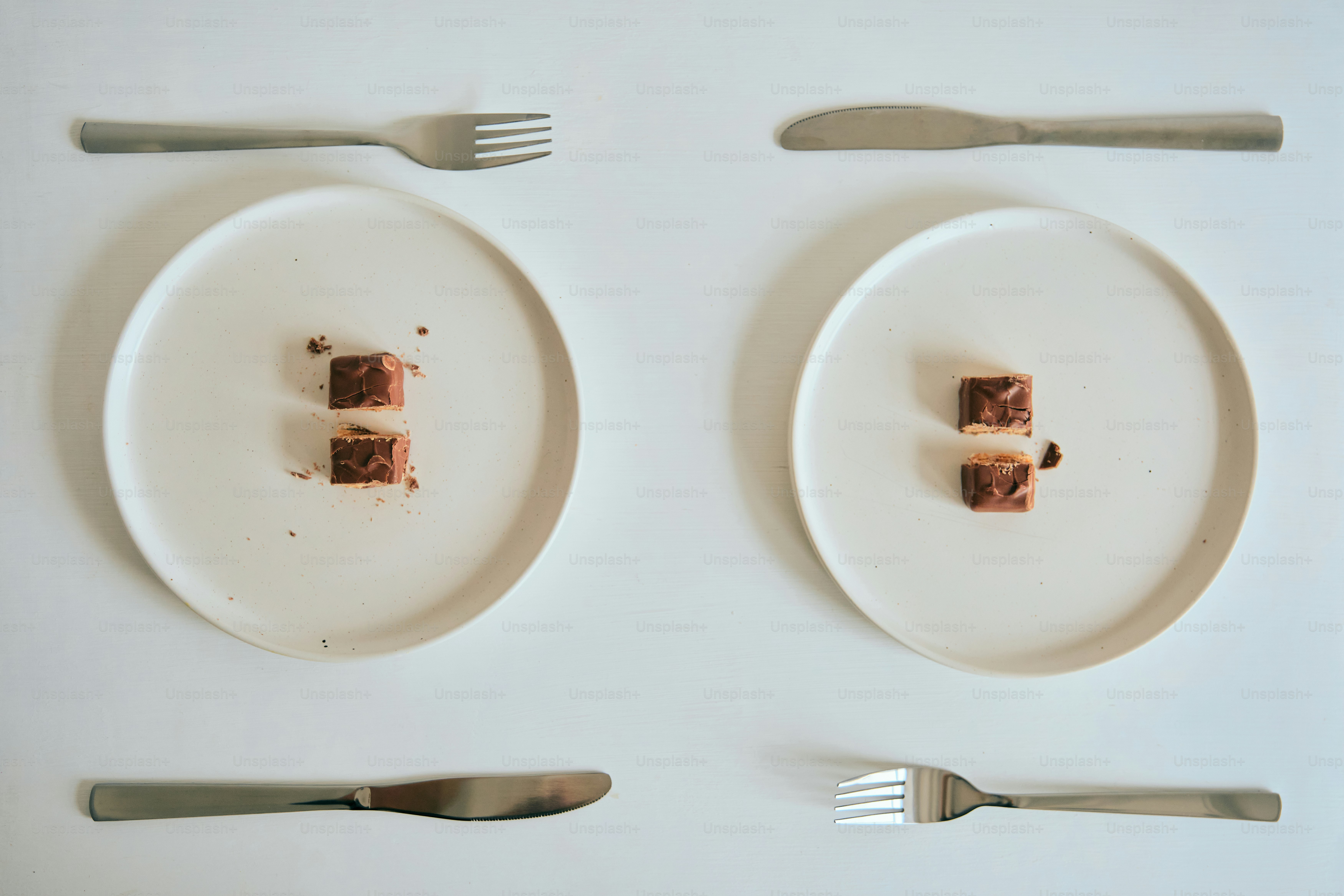 작은 디저트와 수저류가 어레인지된 두 접시.