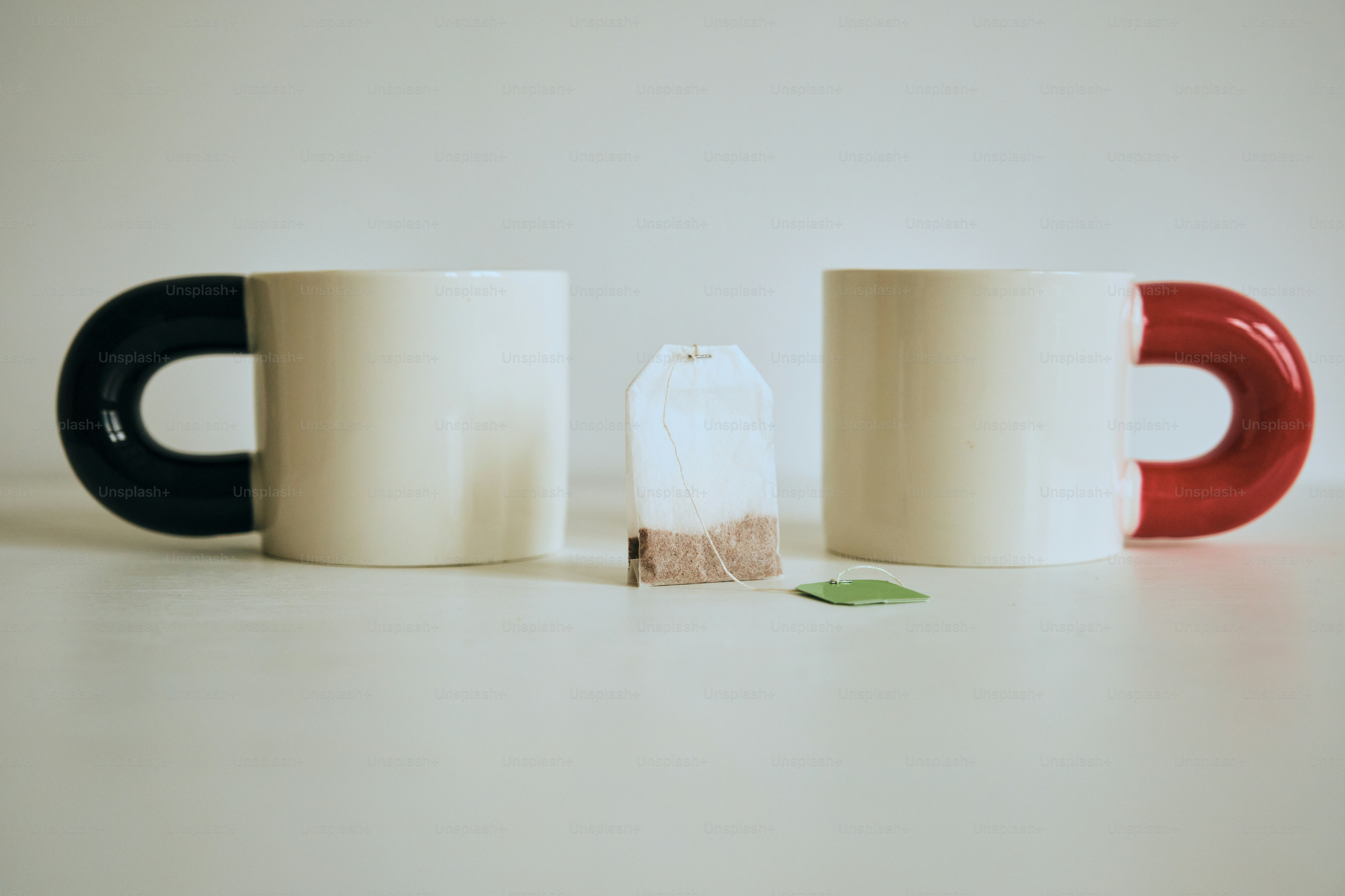 Zwei Tassen mit einem Teebeutel dazwischen