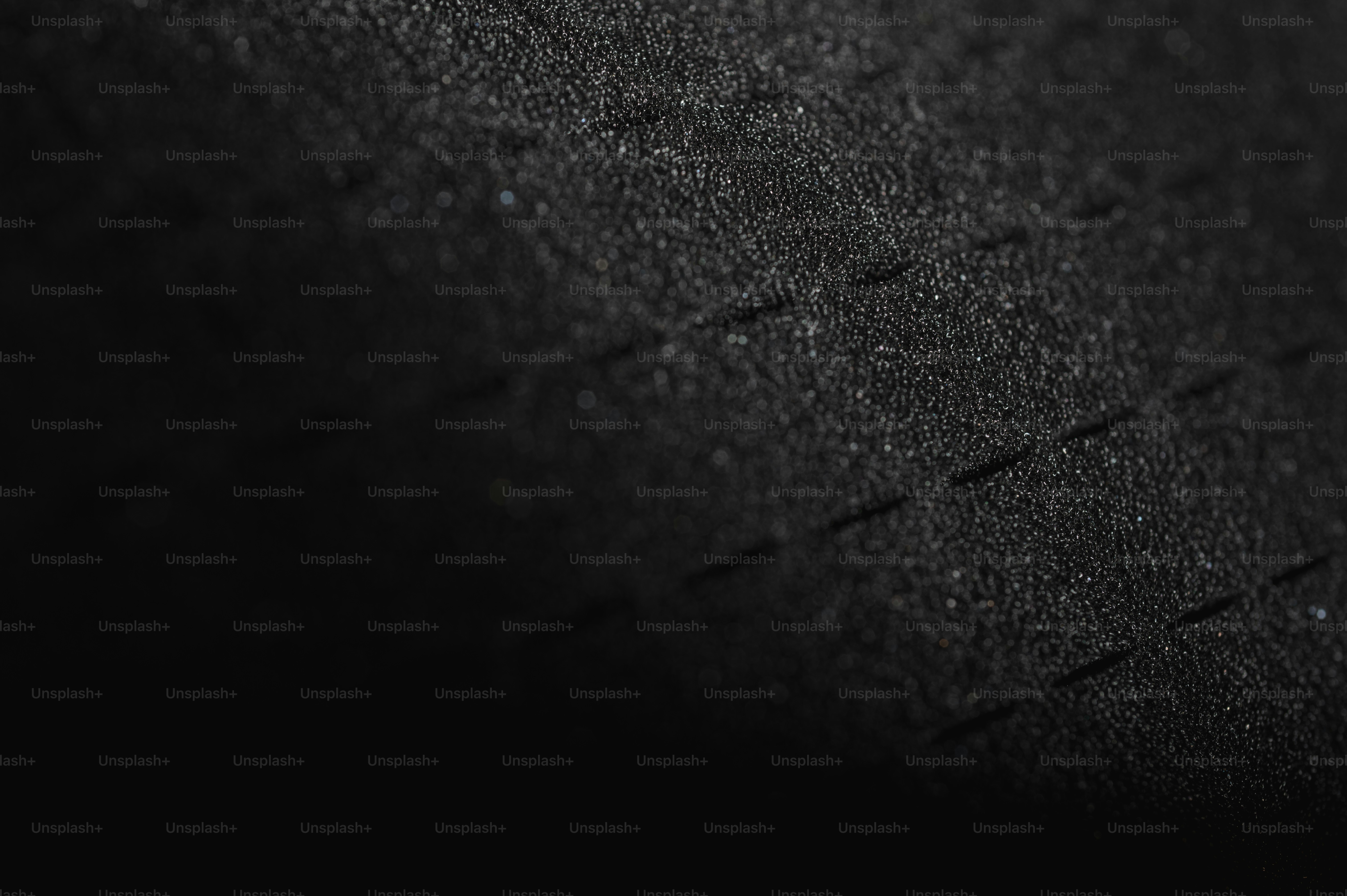 Primer plano de una superficie negra texturizada con un sutil patrón de cuadrícula.