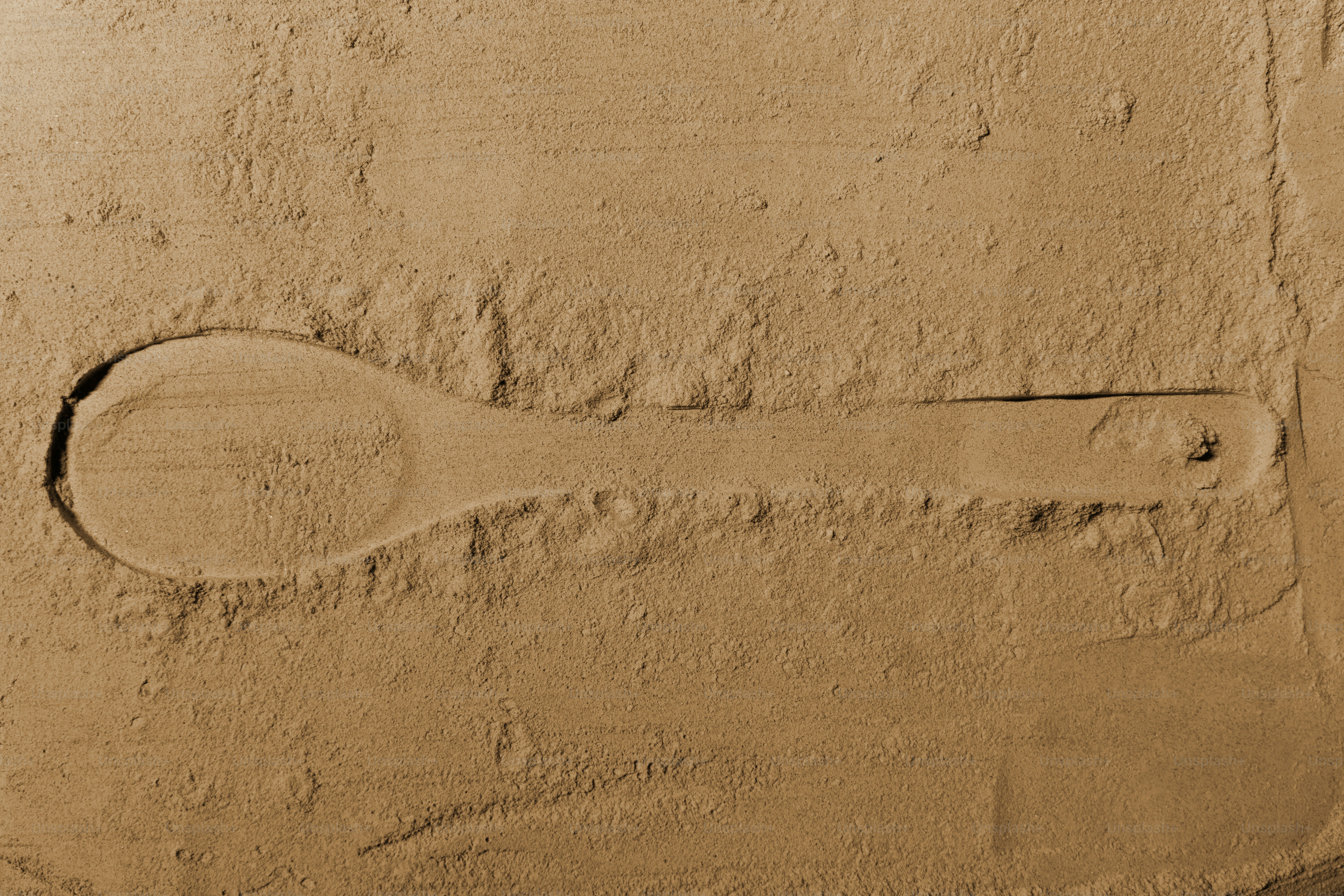 Un cucchiaio di legno pressato in polvere marrone