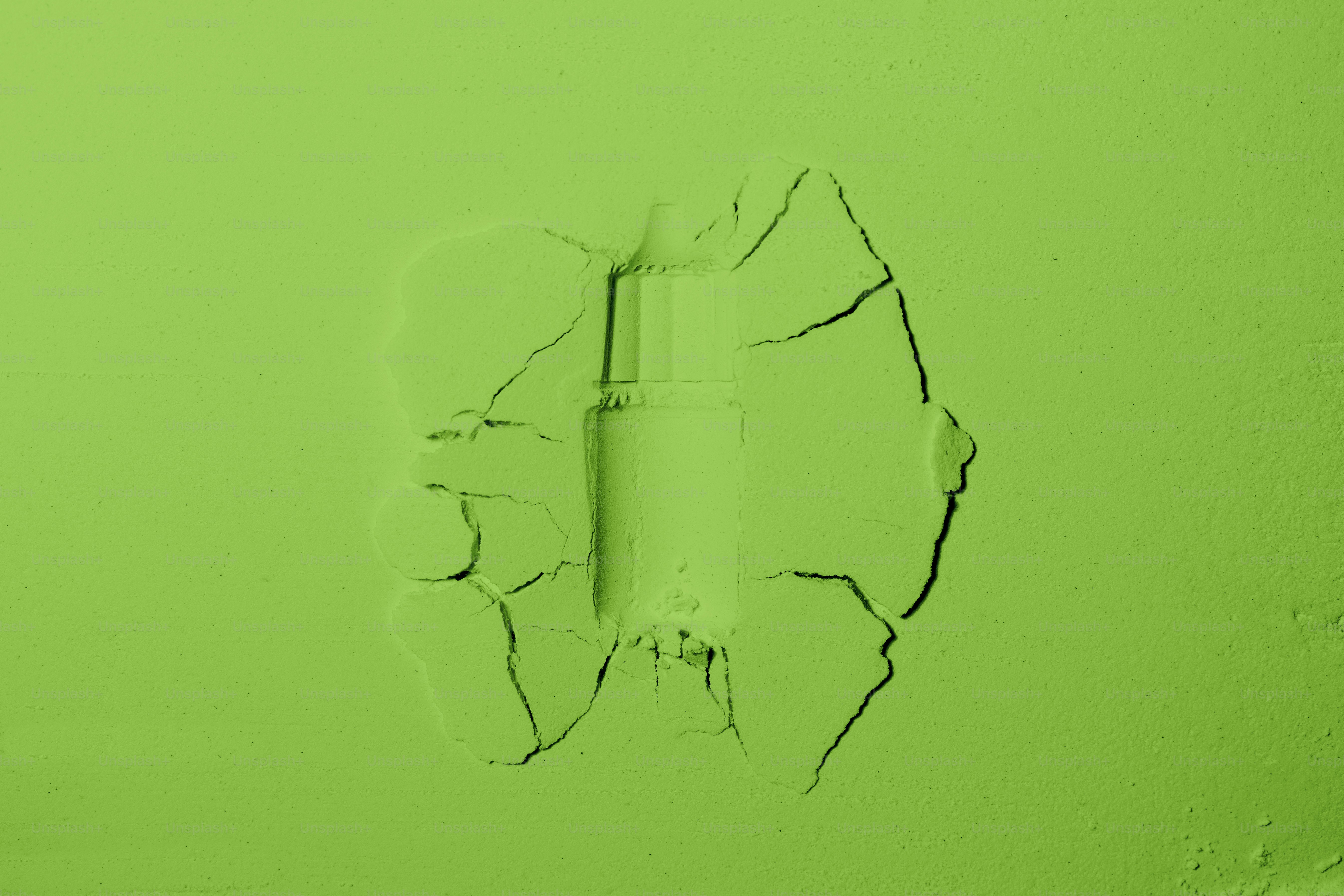 Cracked green surface with a central indentation