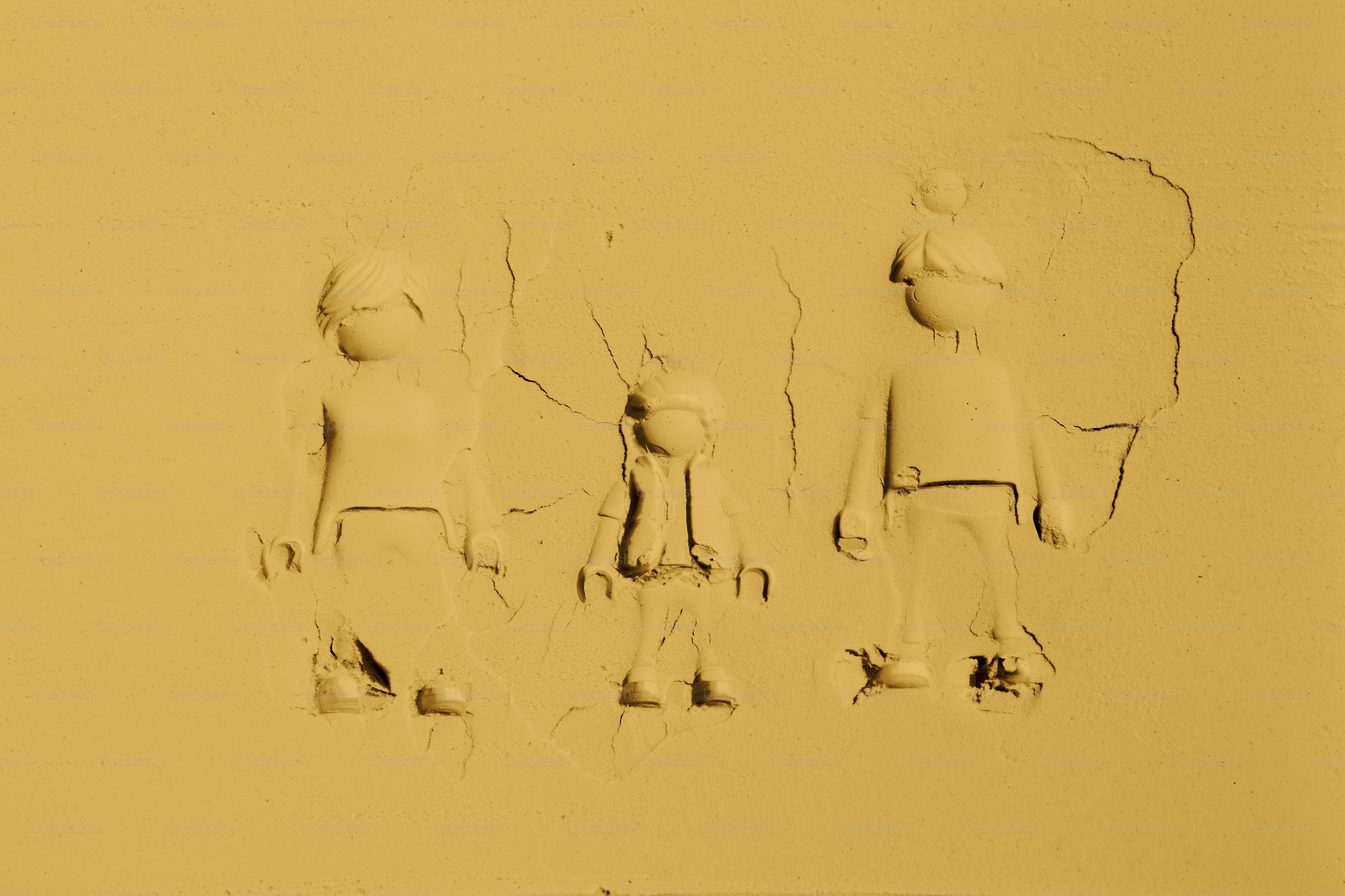 Três figuras pressionadas na areia