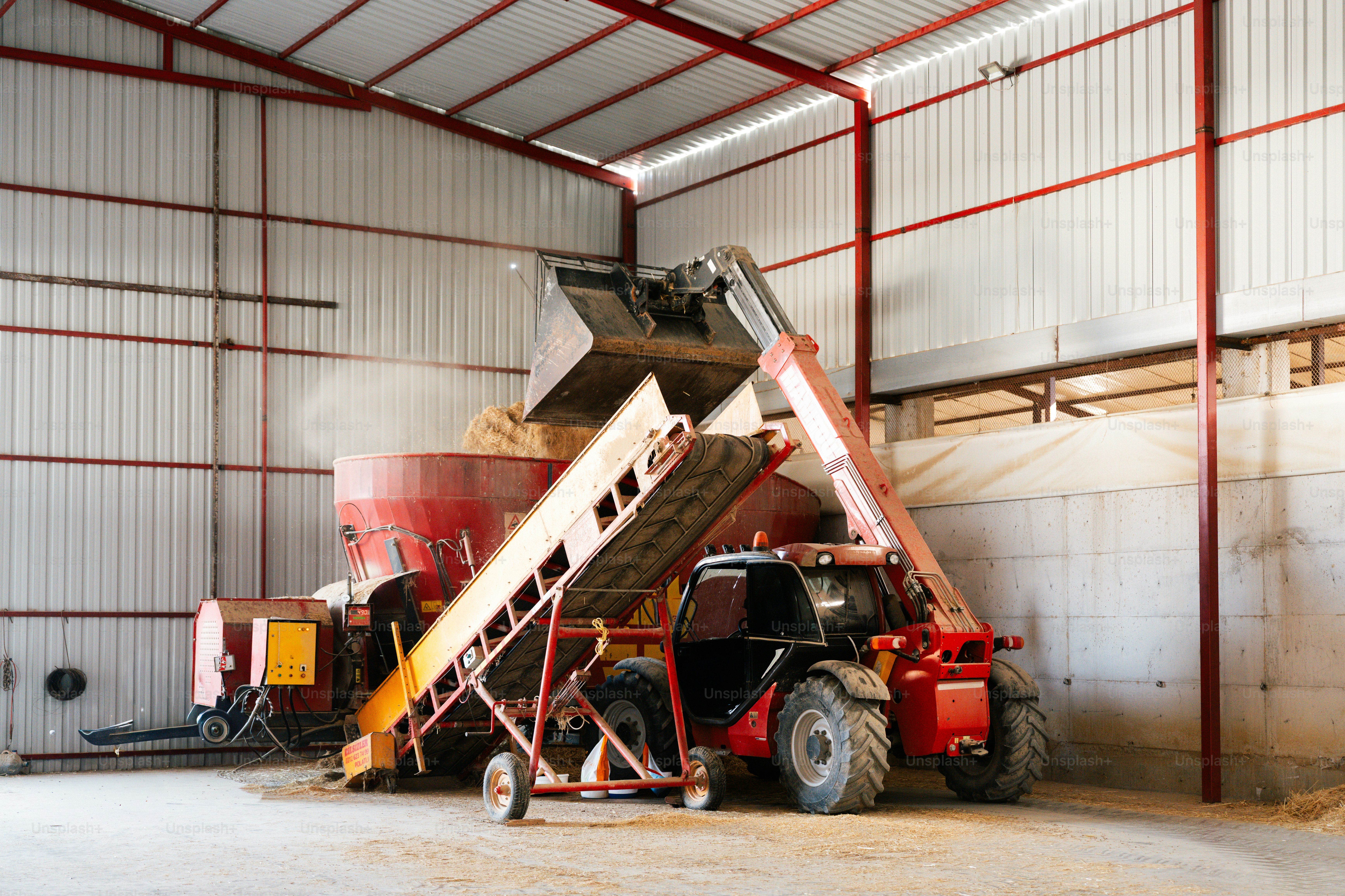 Tractor loading grain into a processing machine