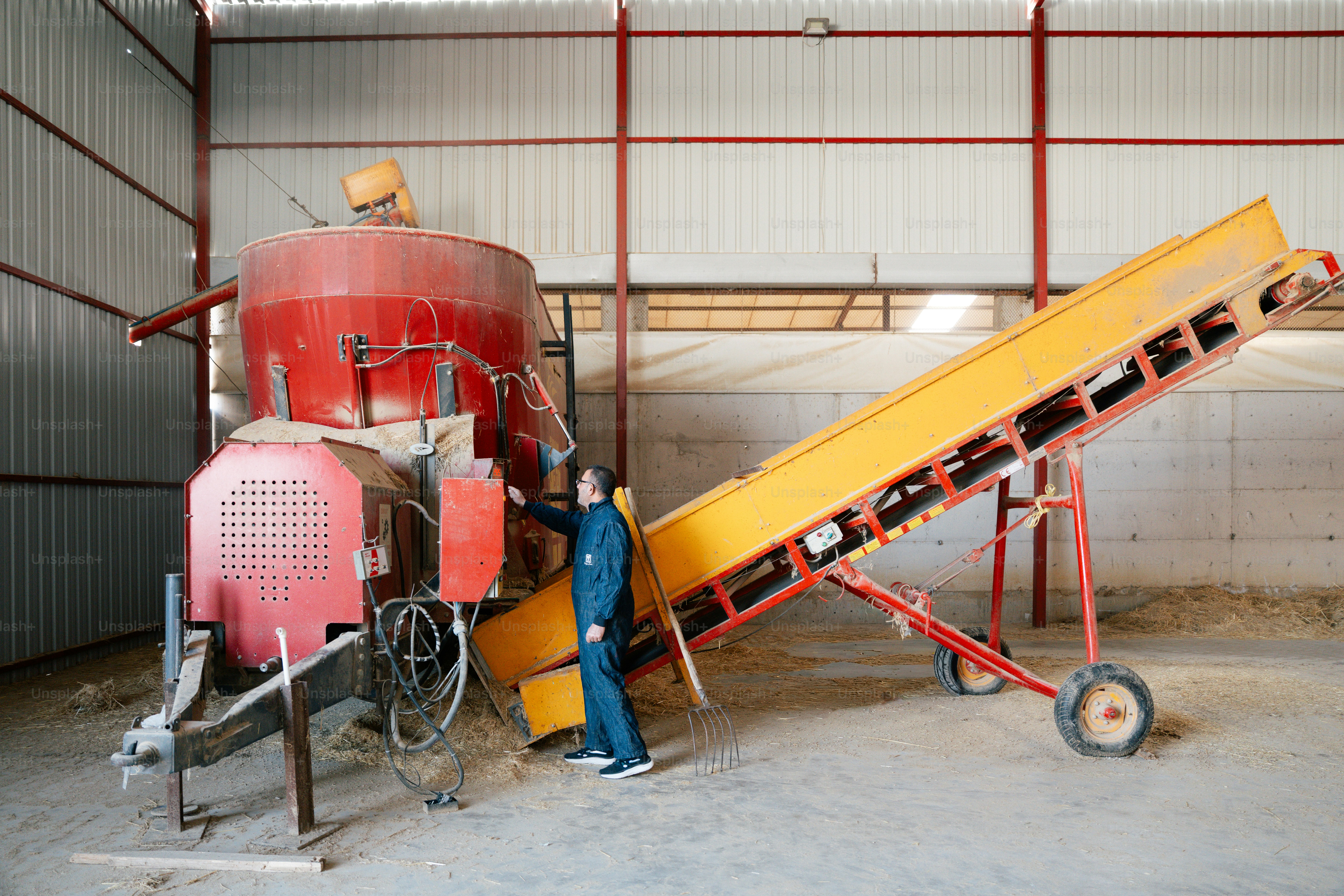 Farmer operating feed mixer machine in barn photo – Pink Image on Unsplash
