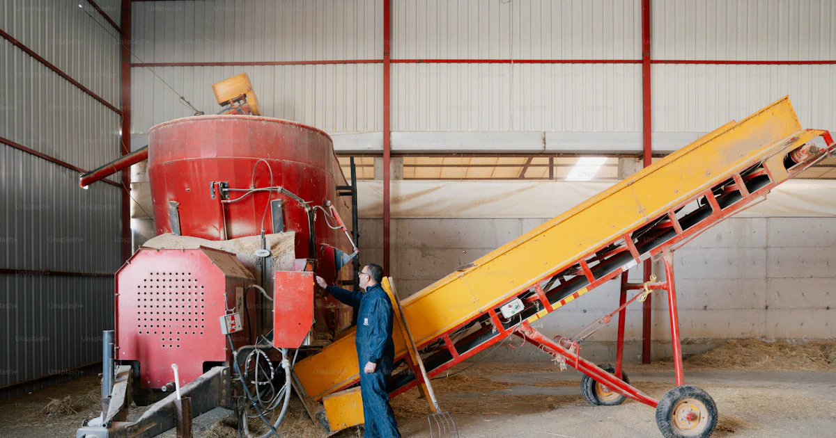 Farmer operating feed mixer machine in barn photo – Pink Image on Unsplash