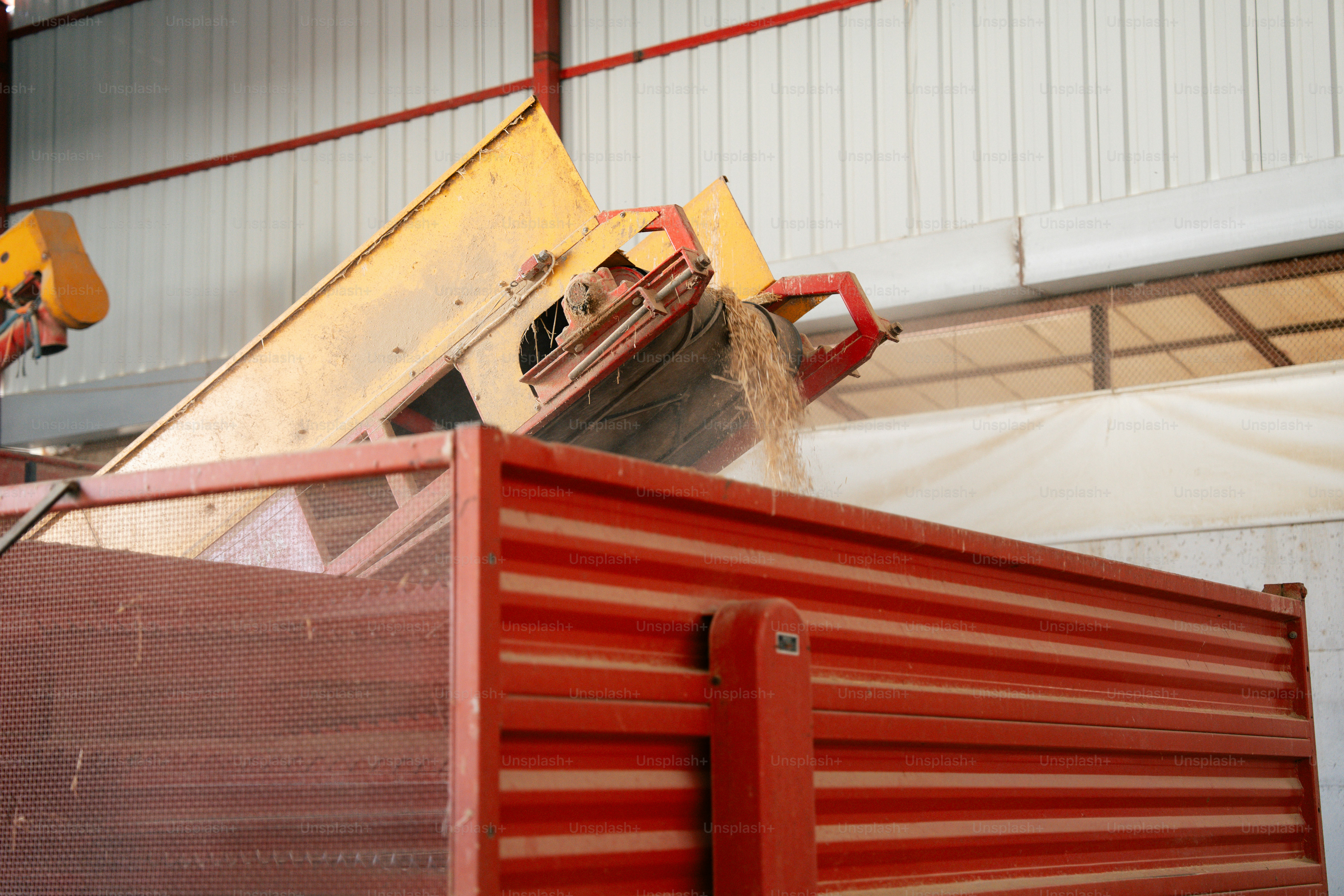 Maquinaria agrícola descargando grano en un camión
