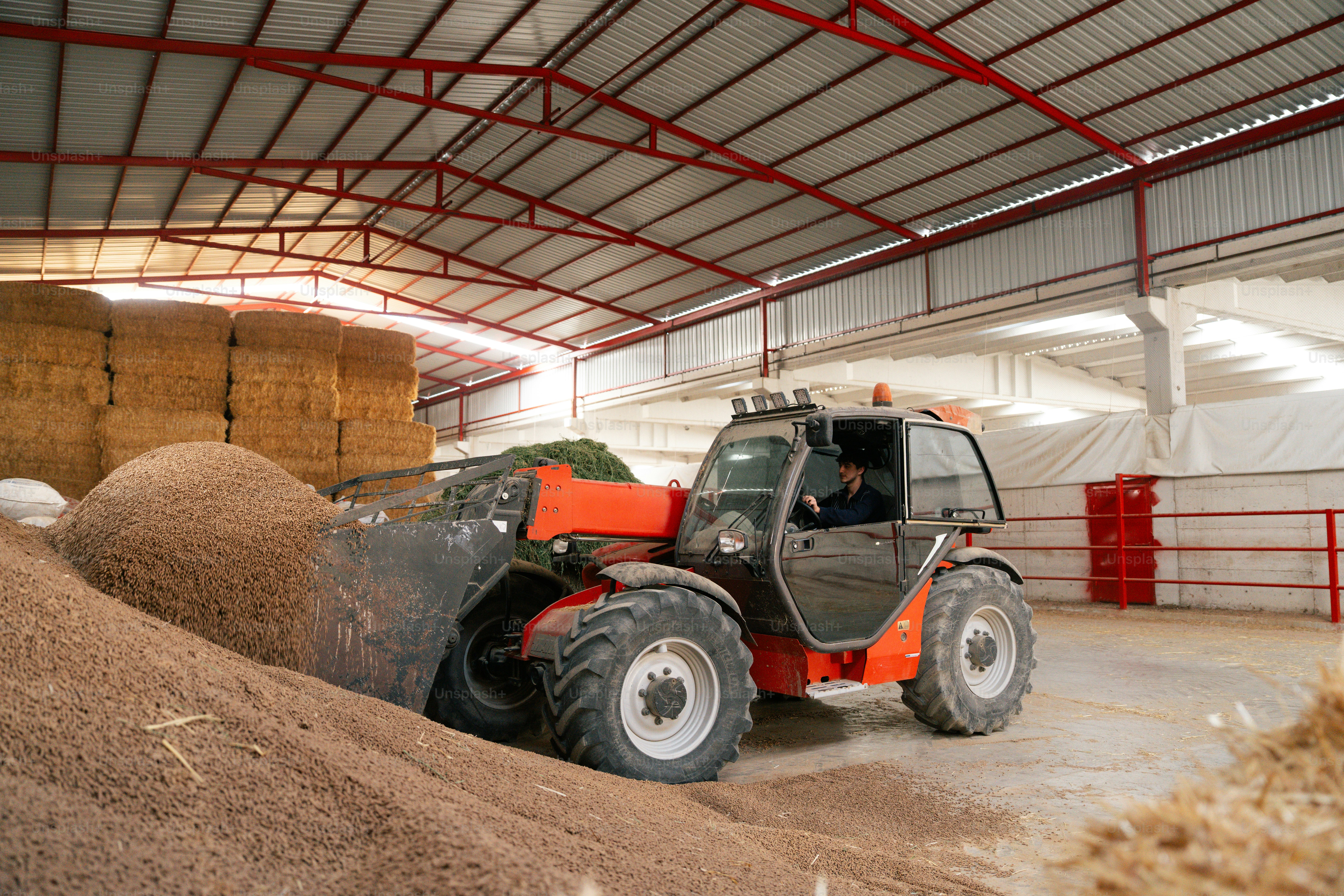 Telehandler moving grain in a large barn