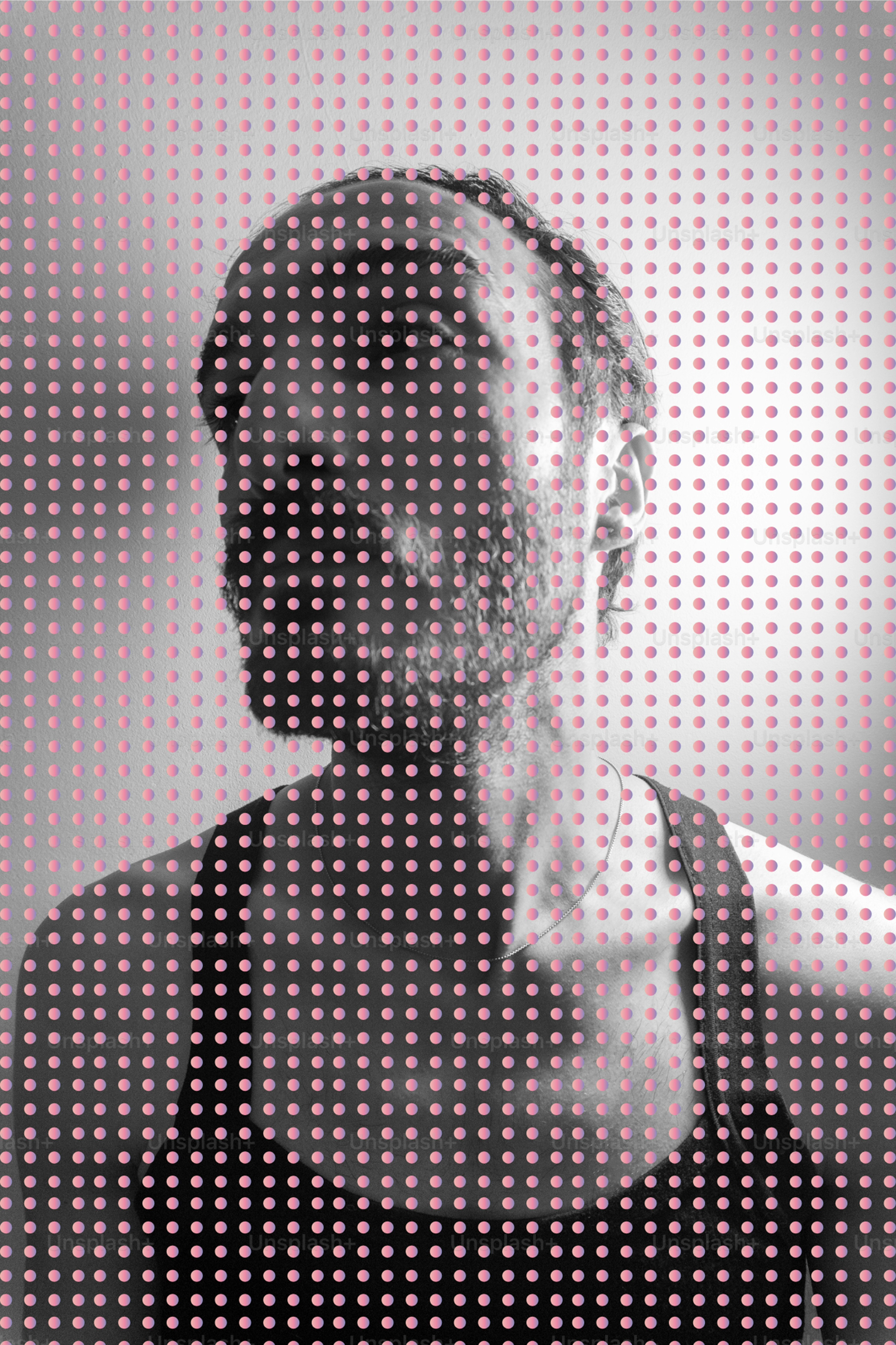 Man's face obscured by pink dots pattern.