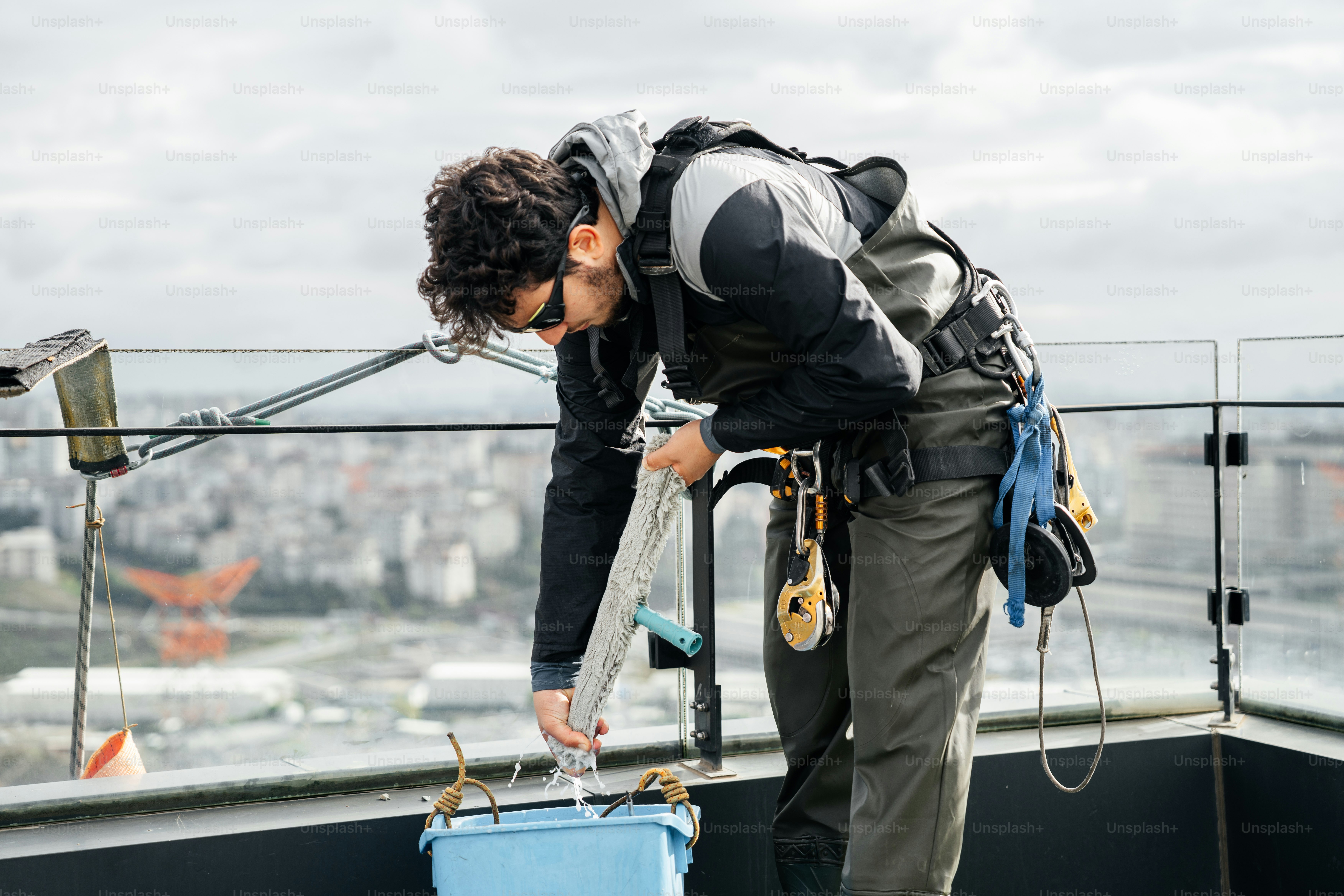 Rooftop worker with safety harness and ropes. photo – Construction ...