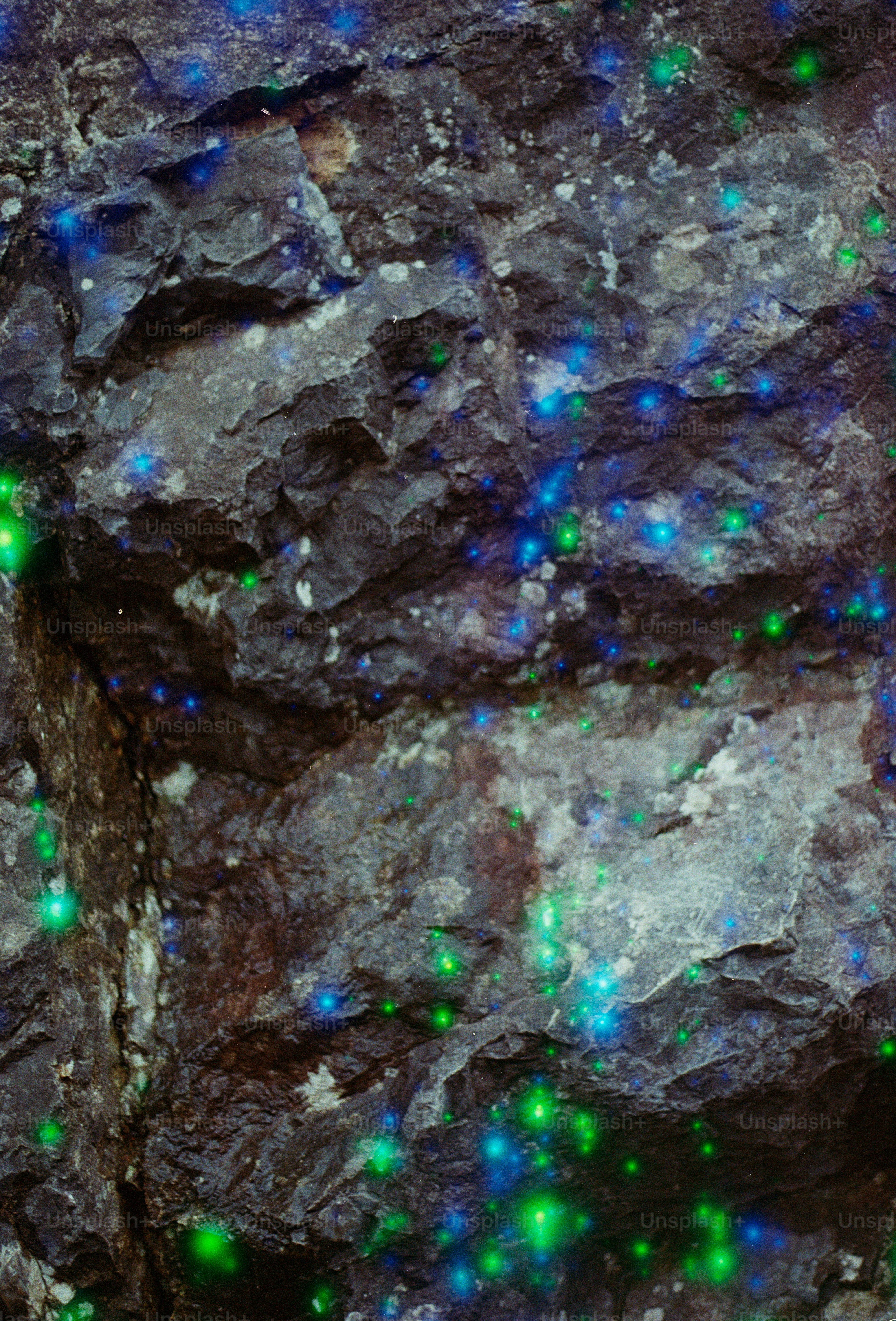 Close-up of glowing blue and green mineral deposits on rock