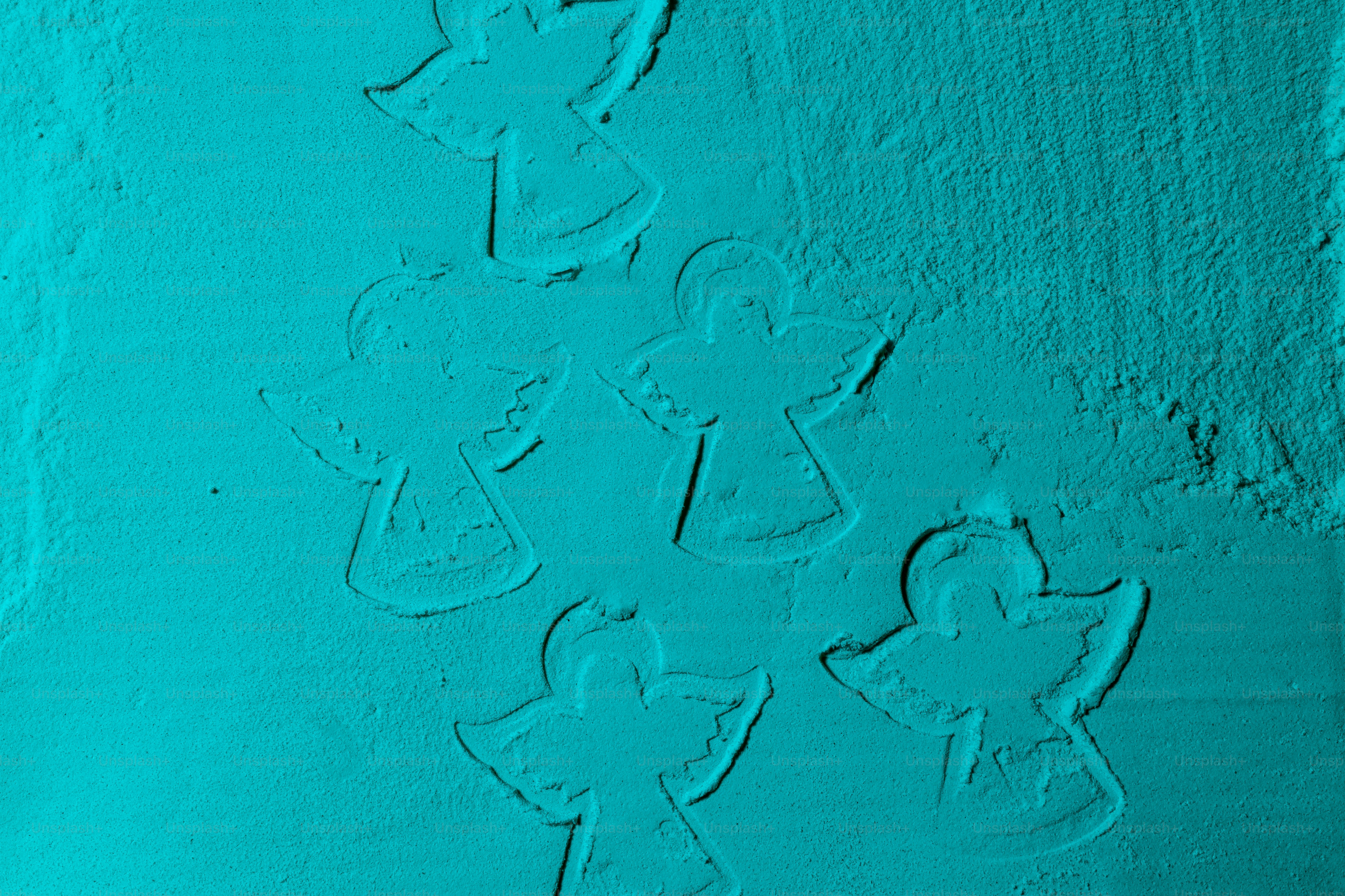 Varios ángeles pequeños en relieve sobre un fondo verde azulado