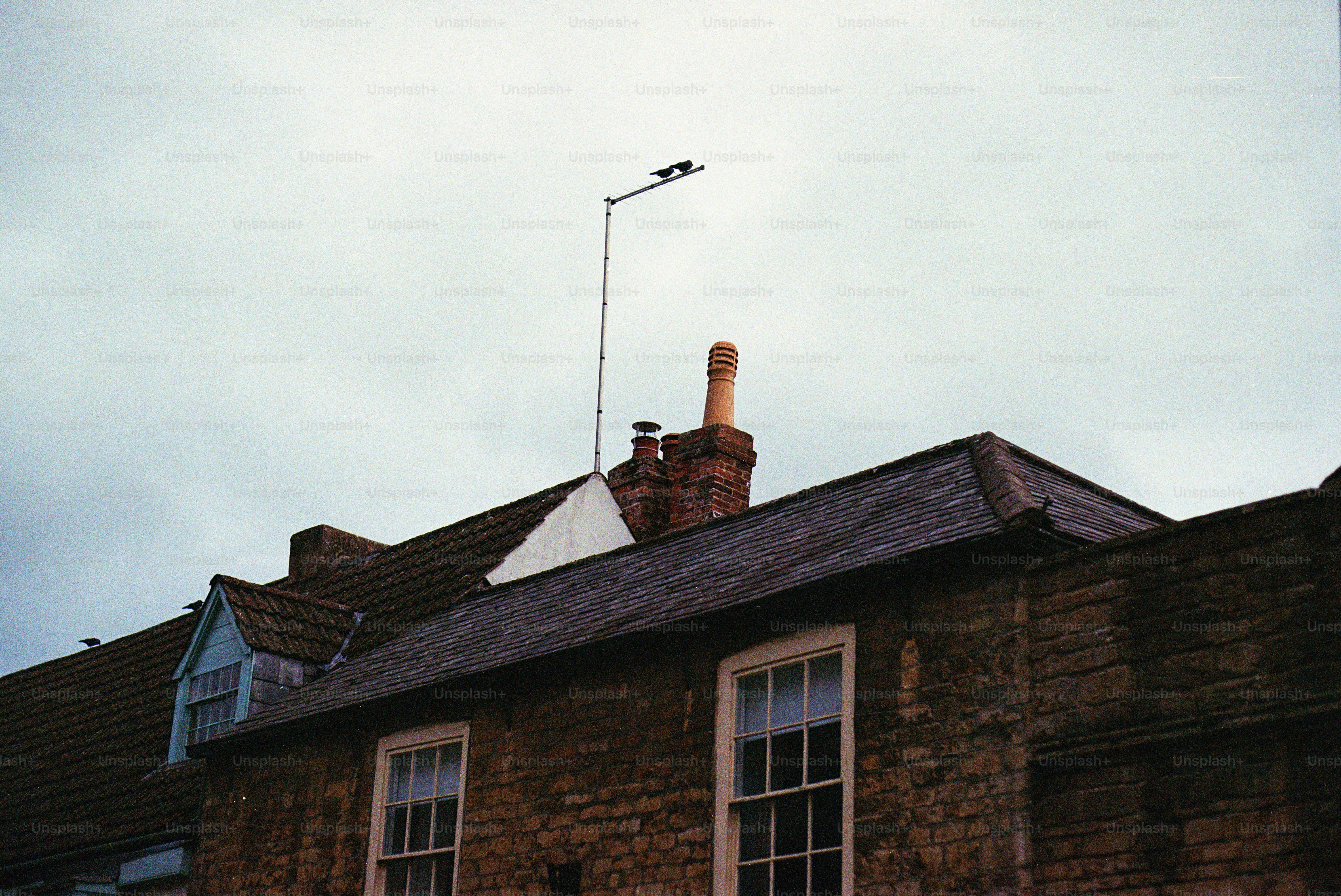 Row of houses with a chimney and antenna.