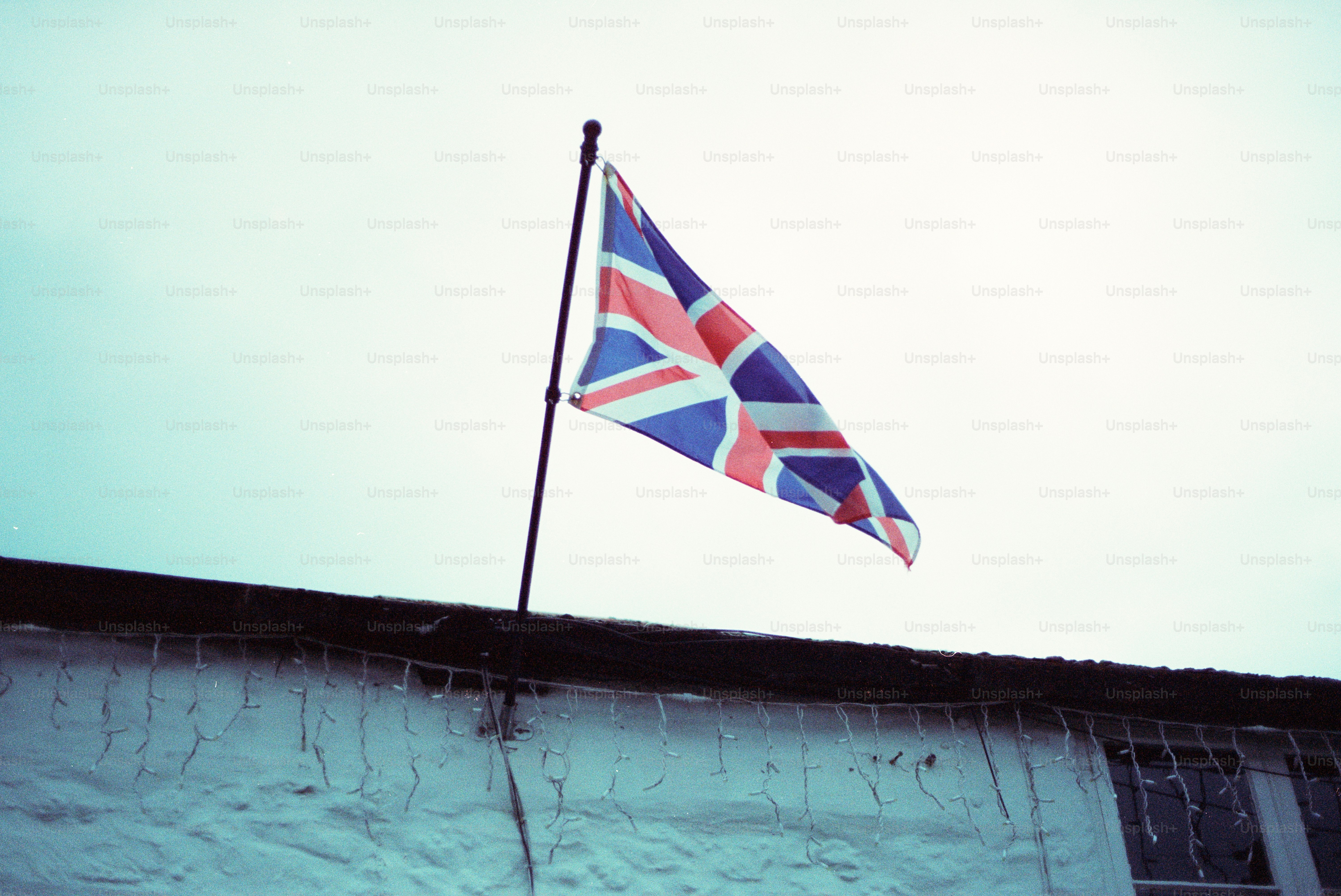 Union jack flag flying against a cloudy sky.