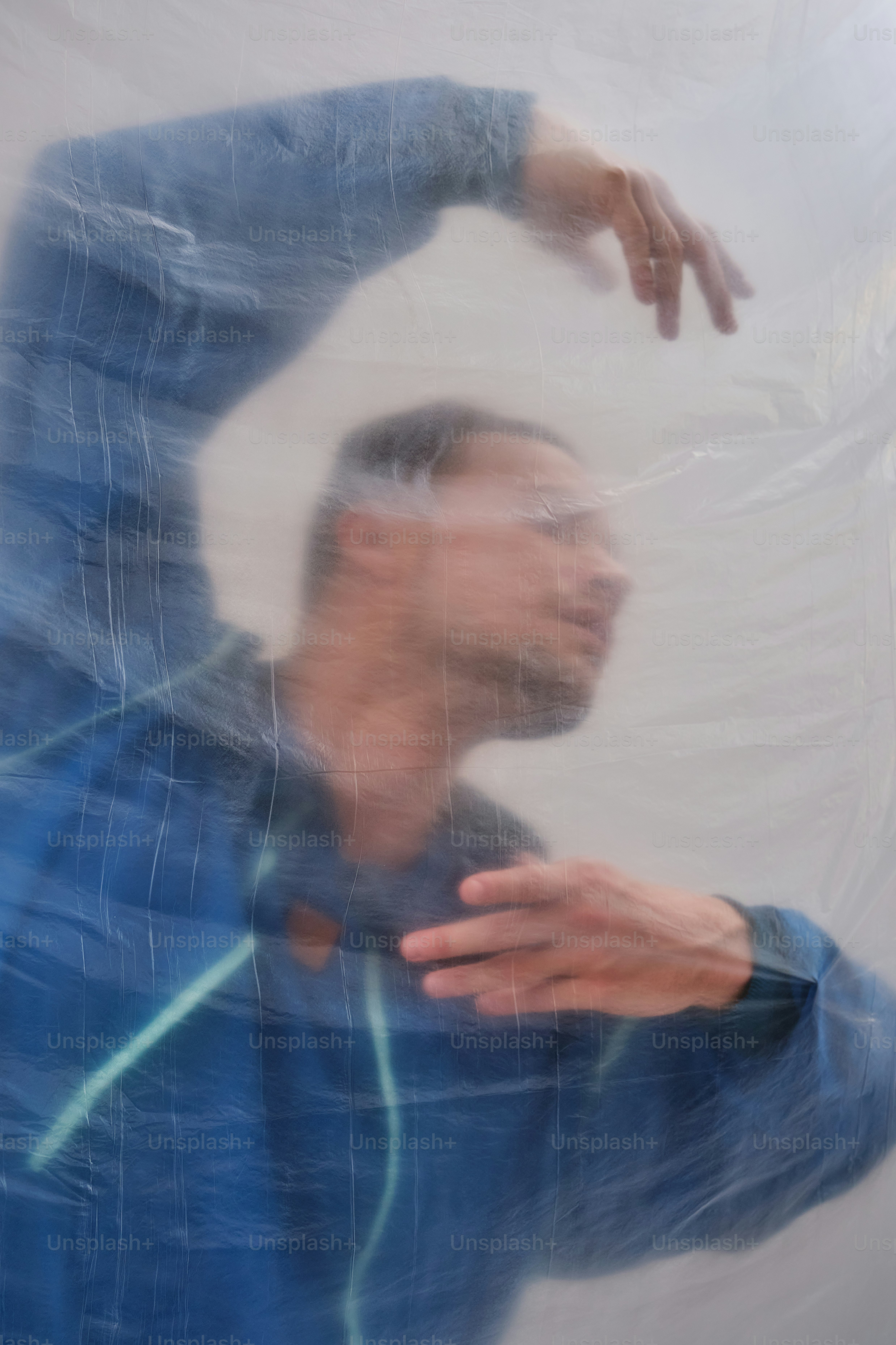 Man in blue jacket seen through plastic wrap photo – Abstract Image on ...