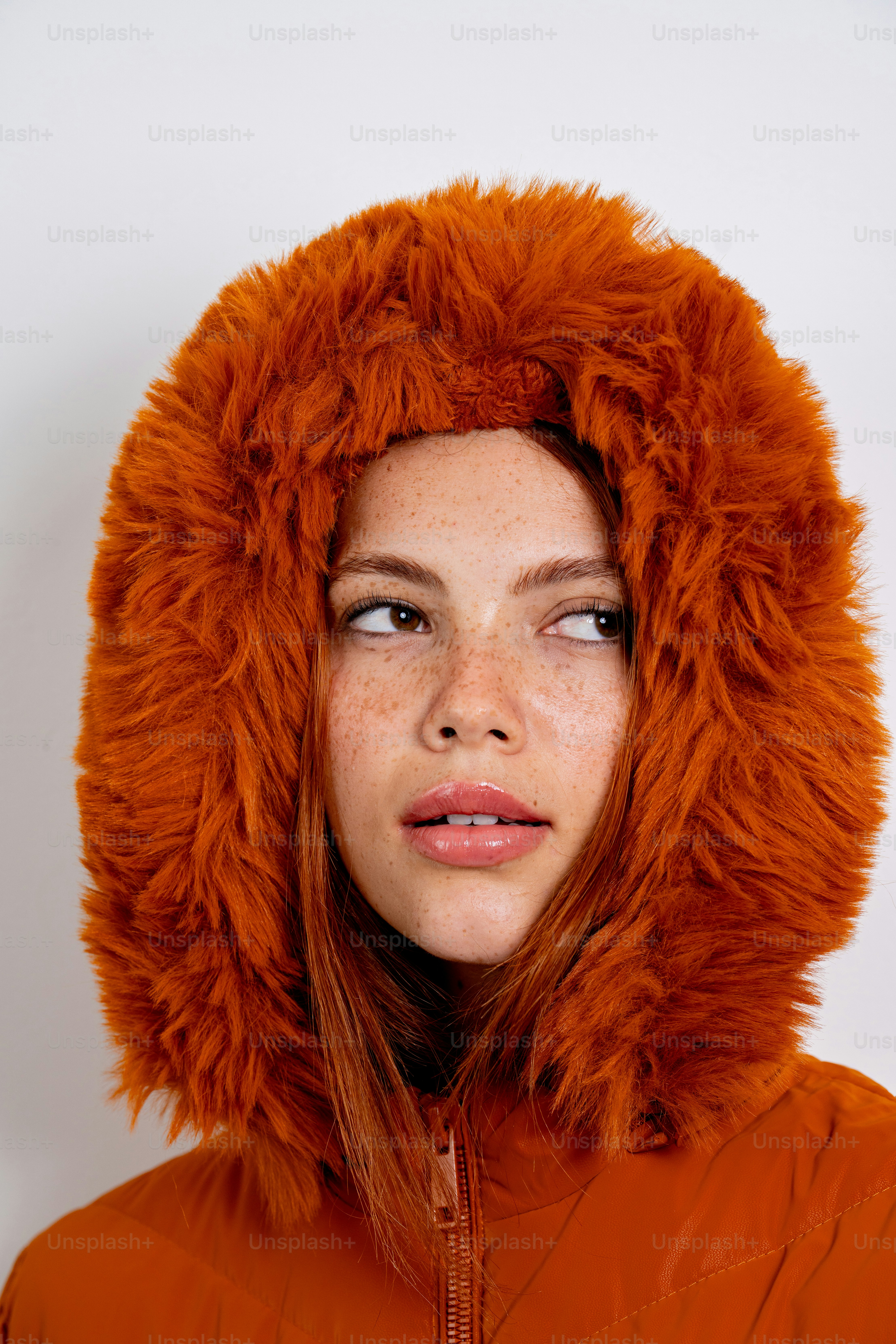 Young woman with freckles wearing a fur-lined hood.