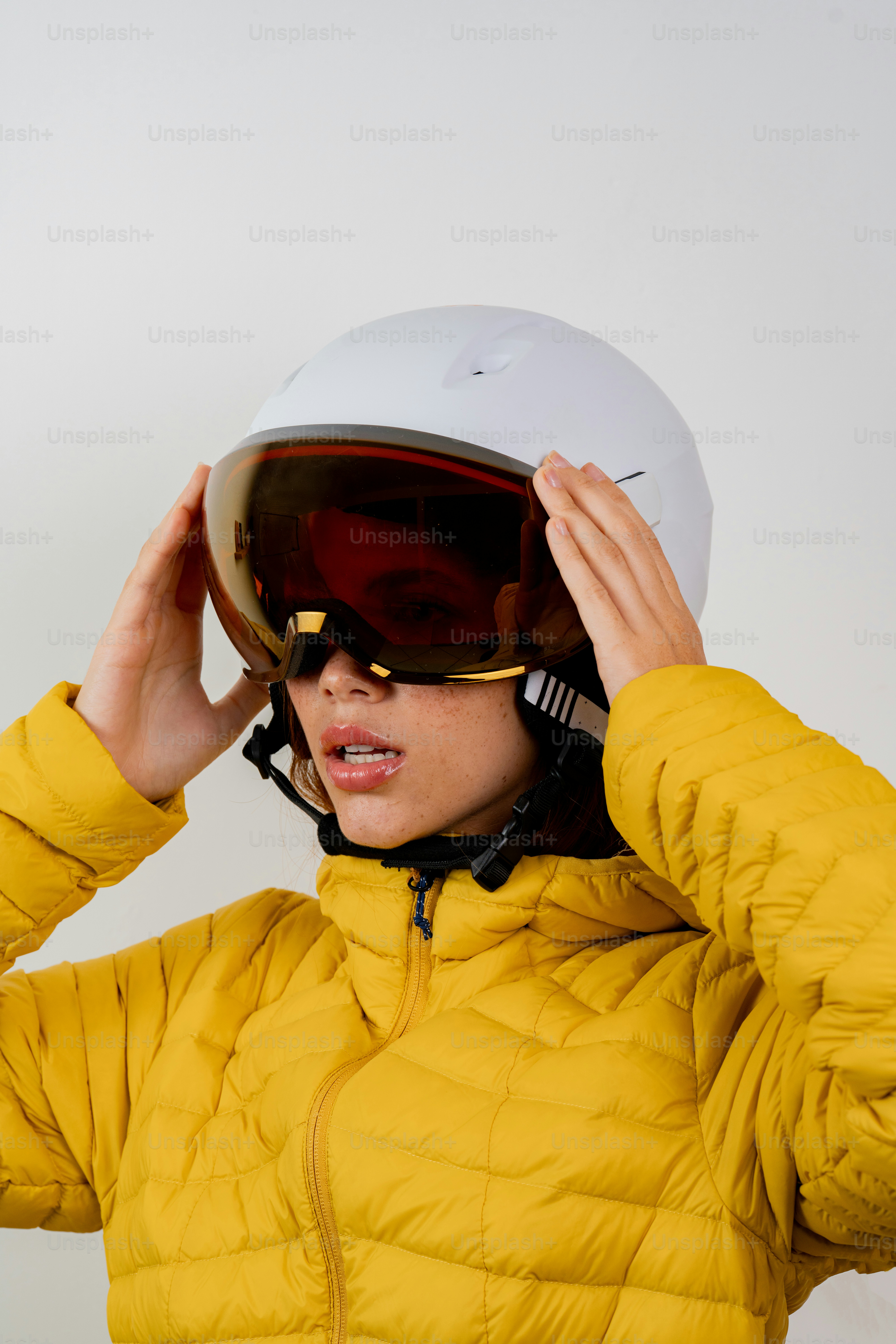 Person wearing a yellow ski jacket and white helmet