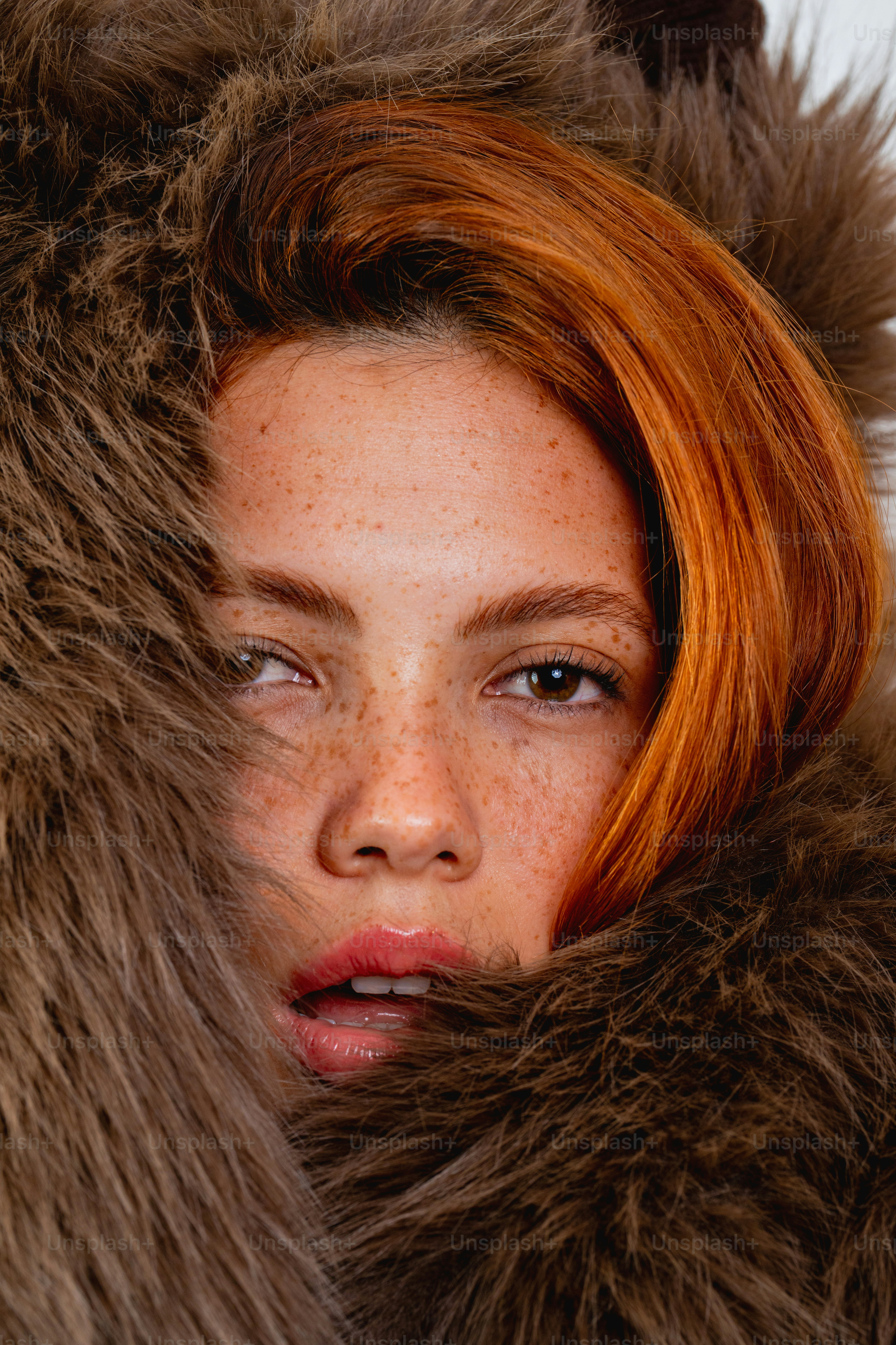 Young woman with red hair and freckles in fur