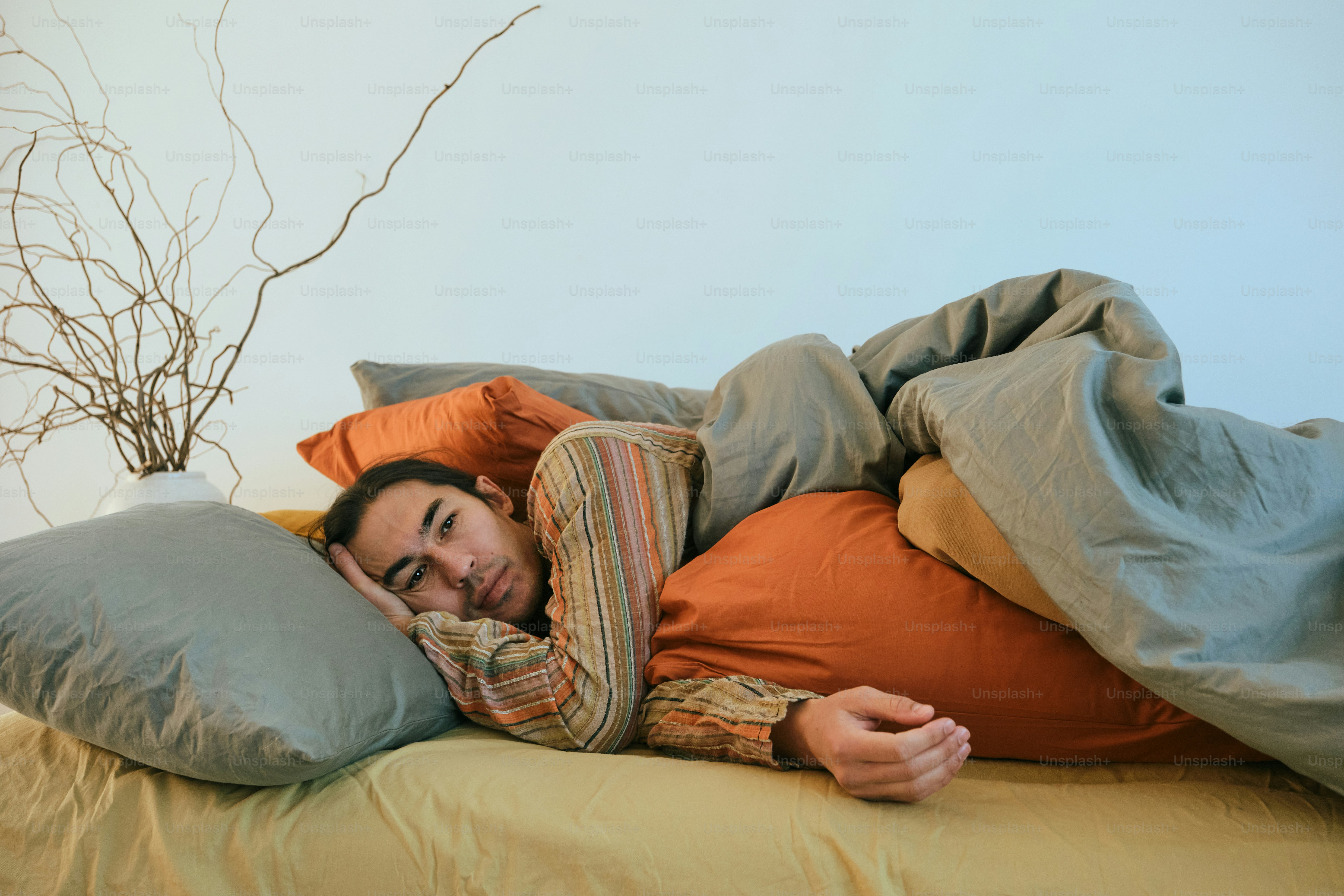 Man sleeping surrounded by many pillows