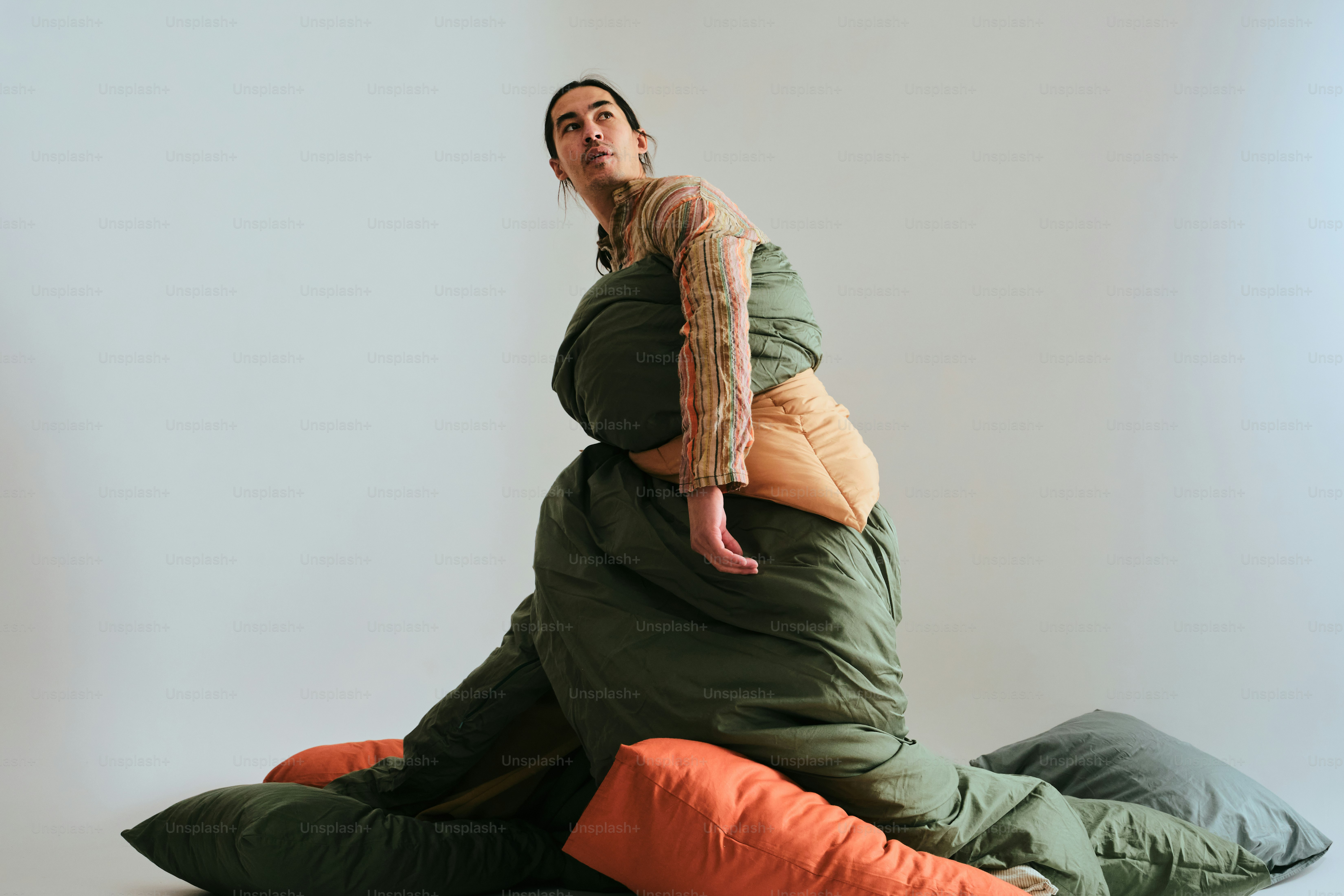 Wanita di kantong tidur dikelilingi bantal