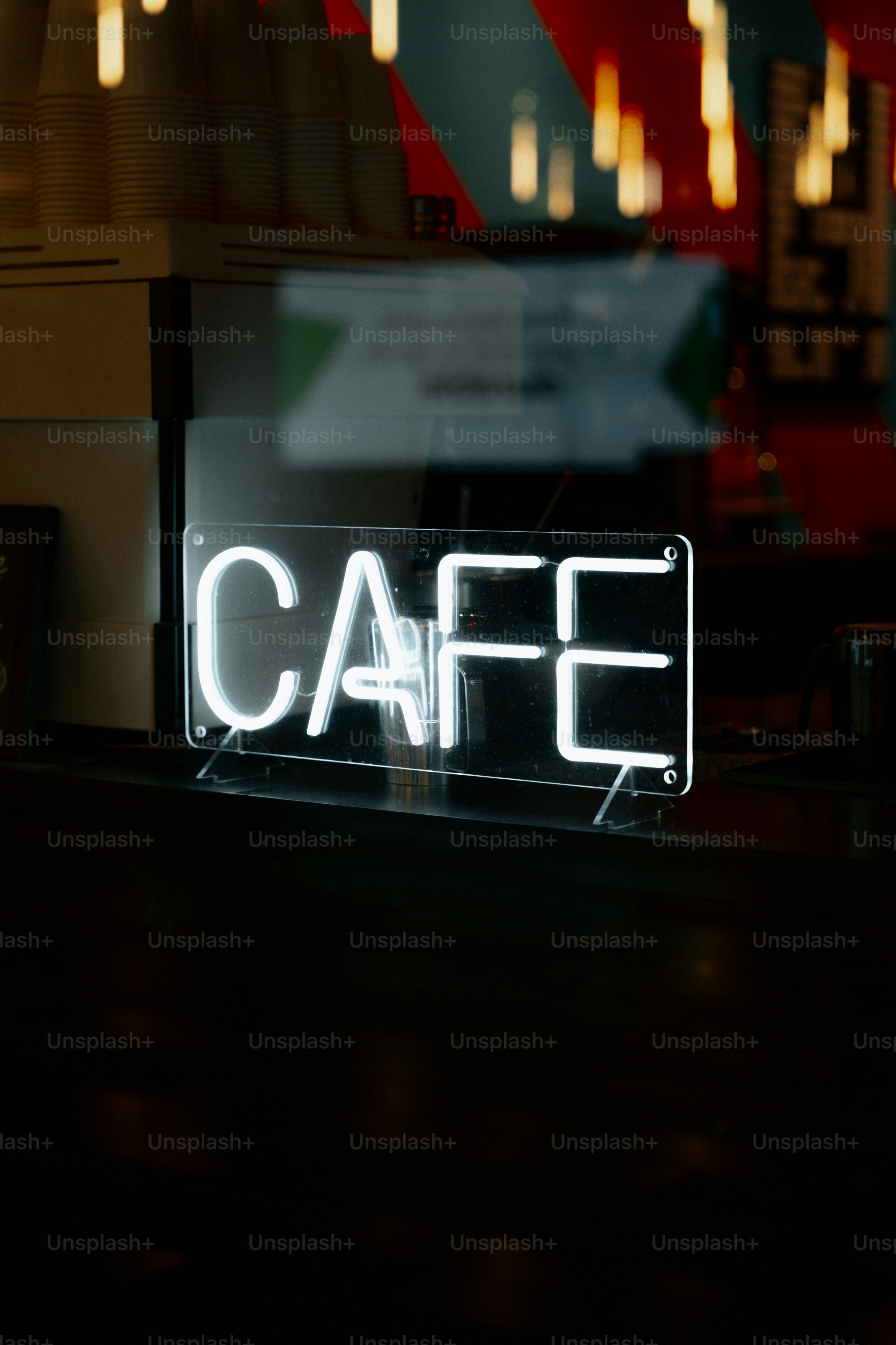 A neon "cafe" sign glows in a dimly lit establishment.