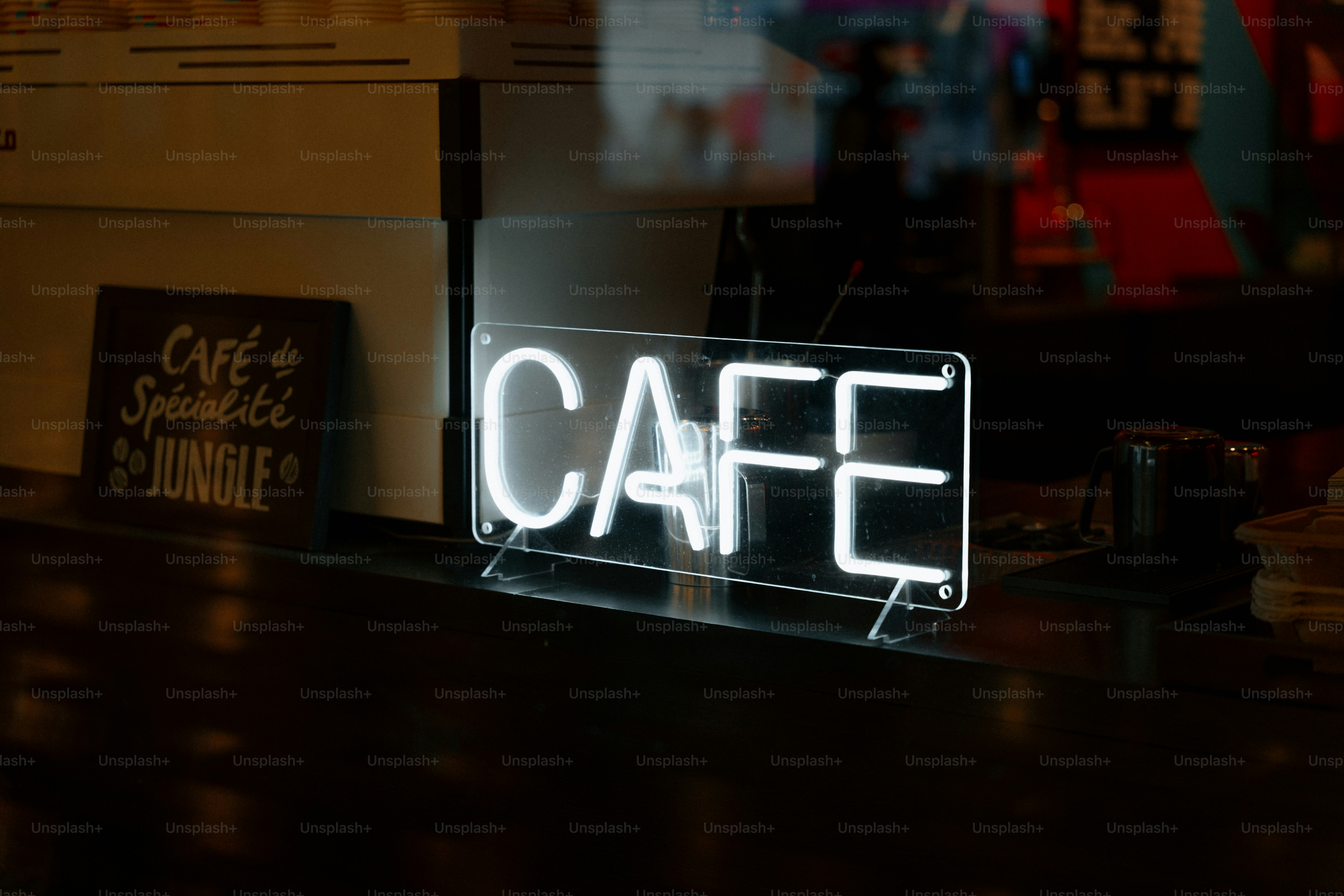 Neon cafe sign illuminated on a dark counter