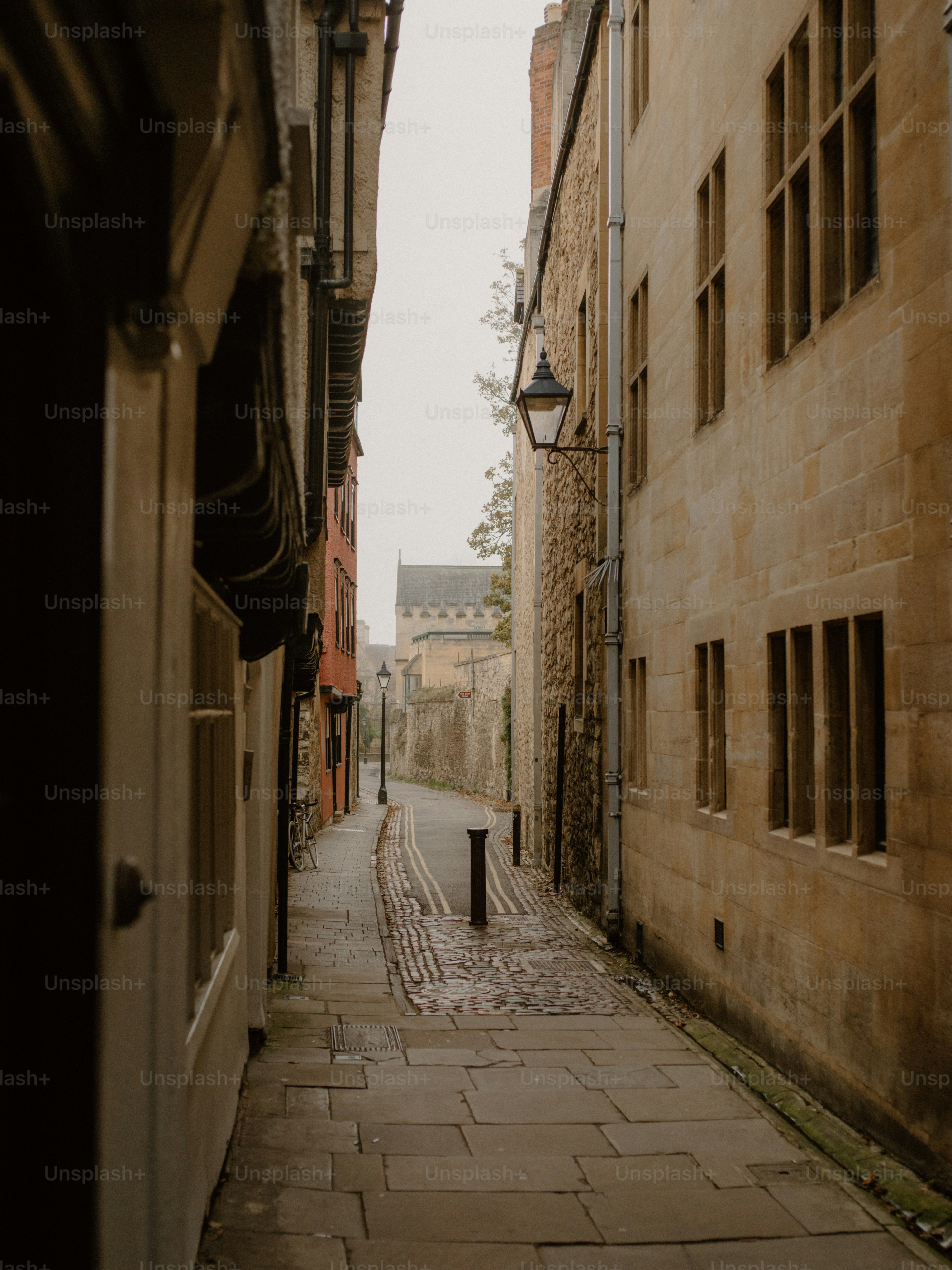 Rua estreita de paralelepípedos entre antigos prédios de pedra.