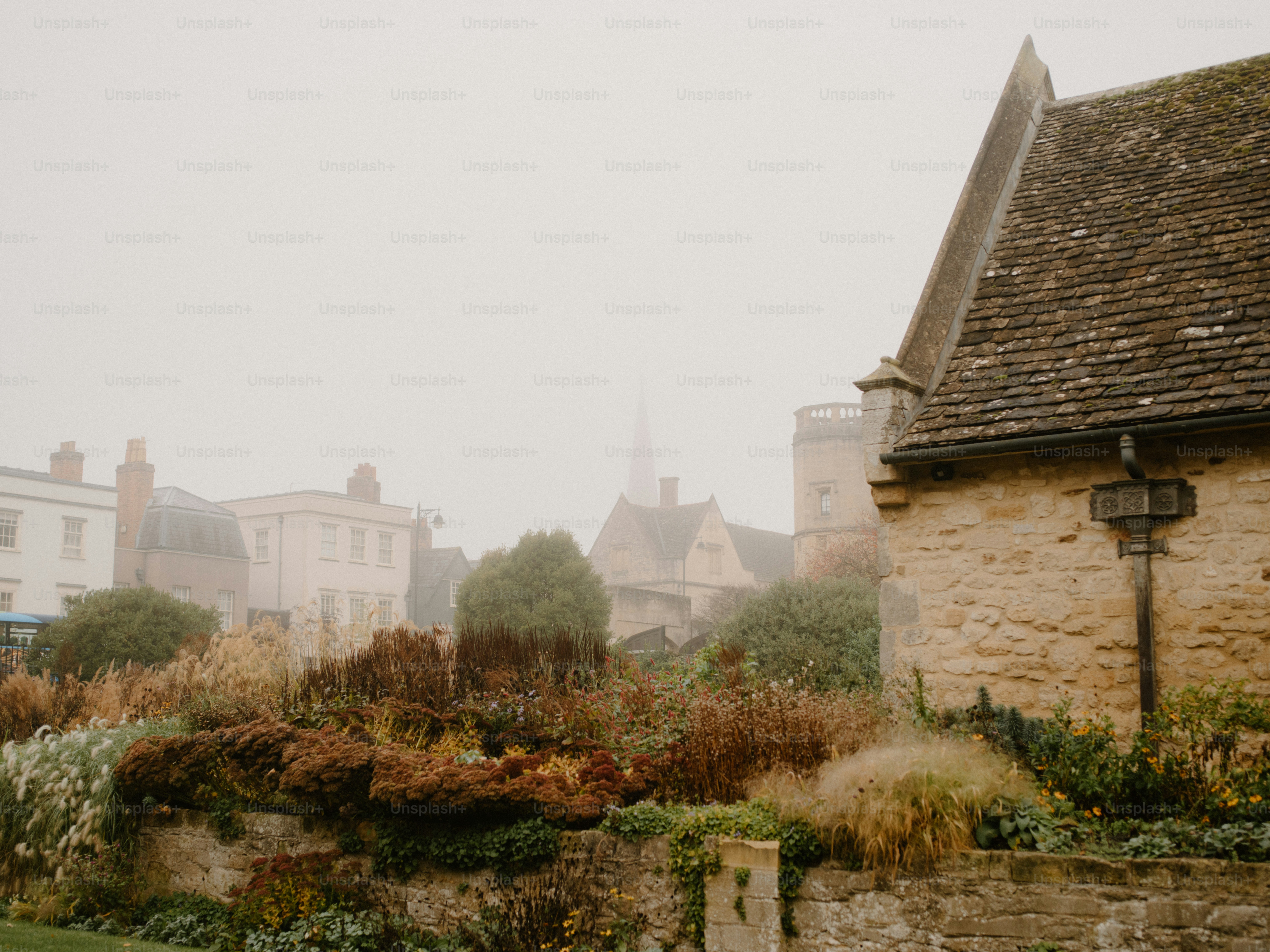 Manhã enevoada sobre uma vila pitoresca com prédios de pedra.