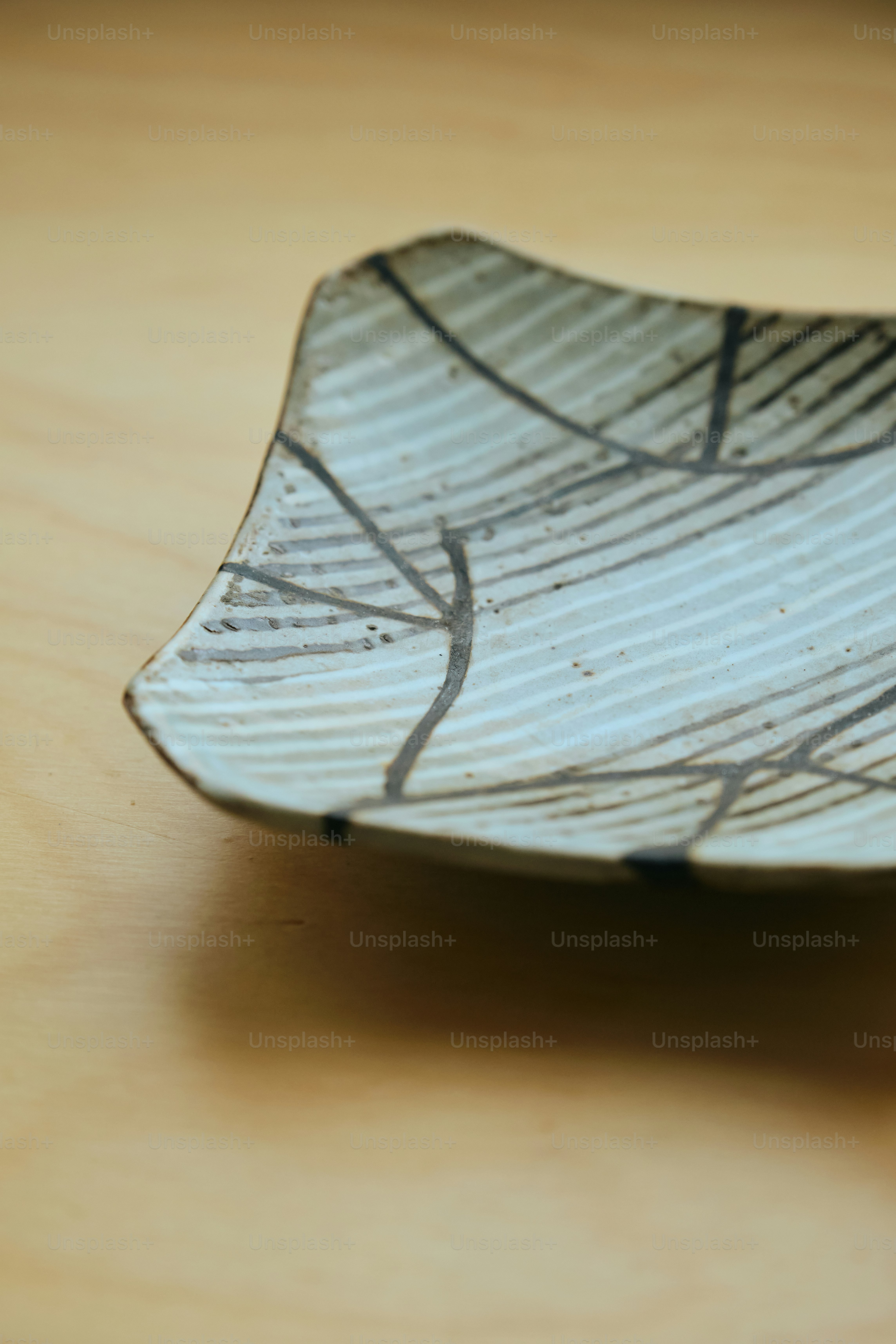 A square ceramic plate with abstract lines.