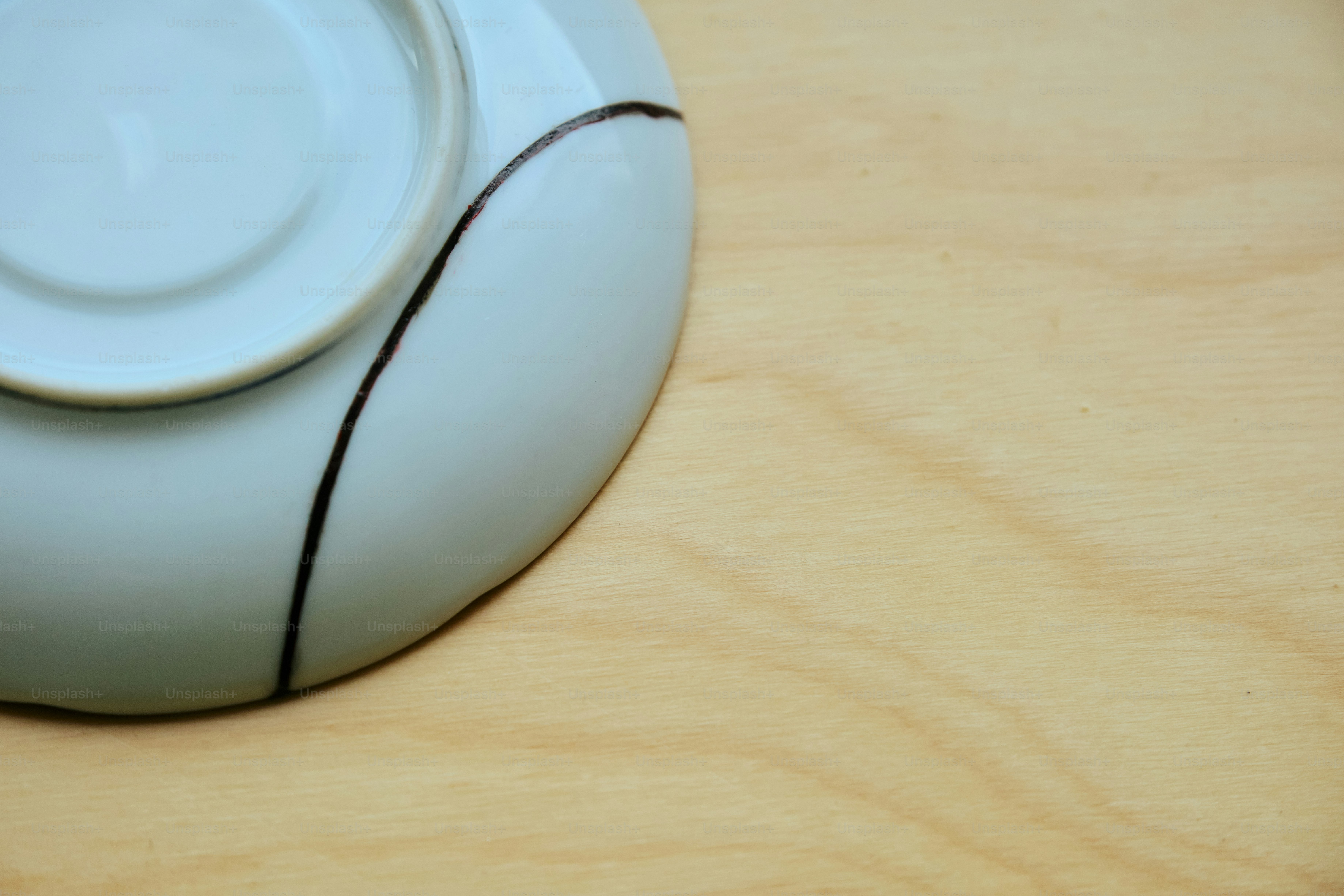 Close-up of a cracked ceramic plate on wood