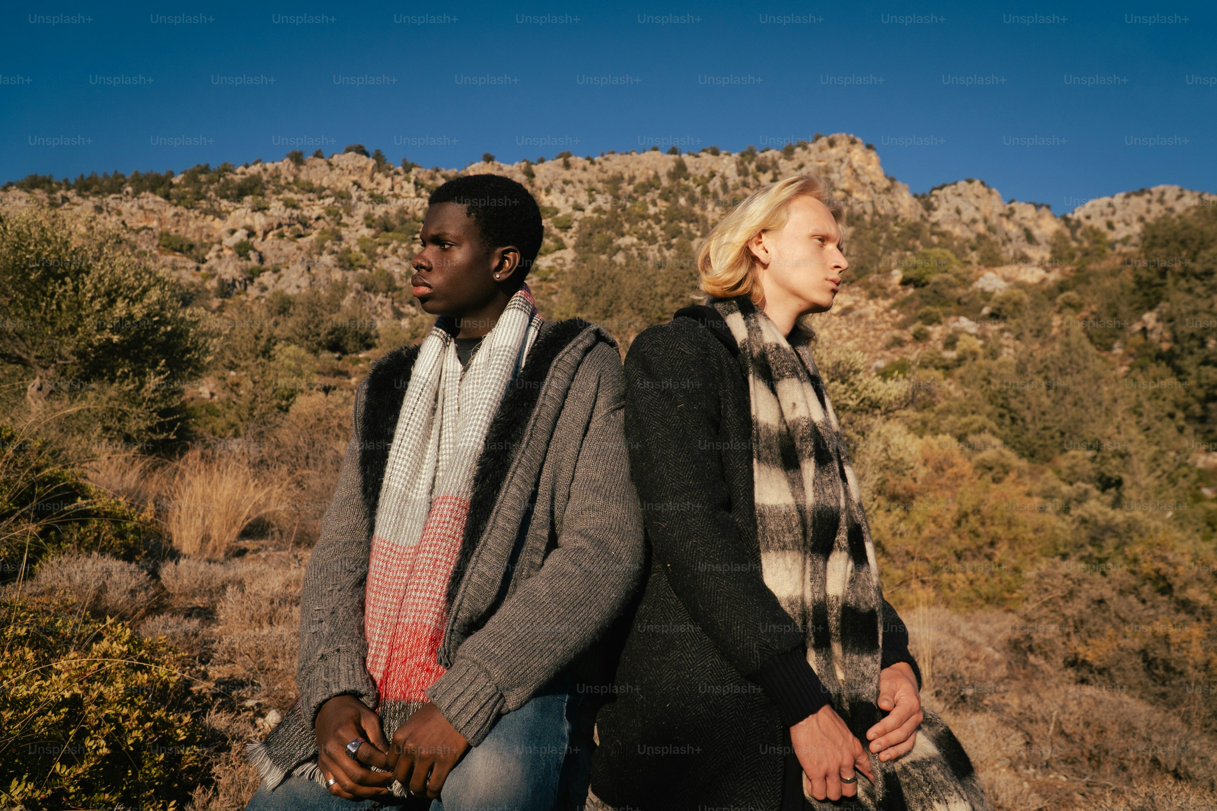 Two people with scarves in a rocky, mountainous landscape.