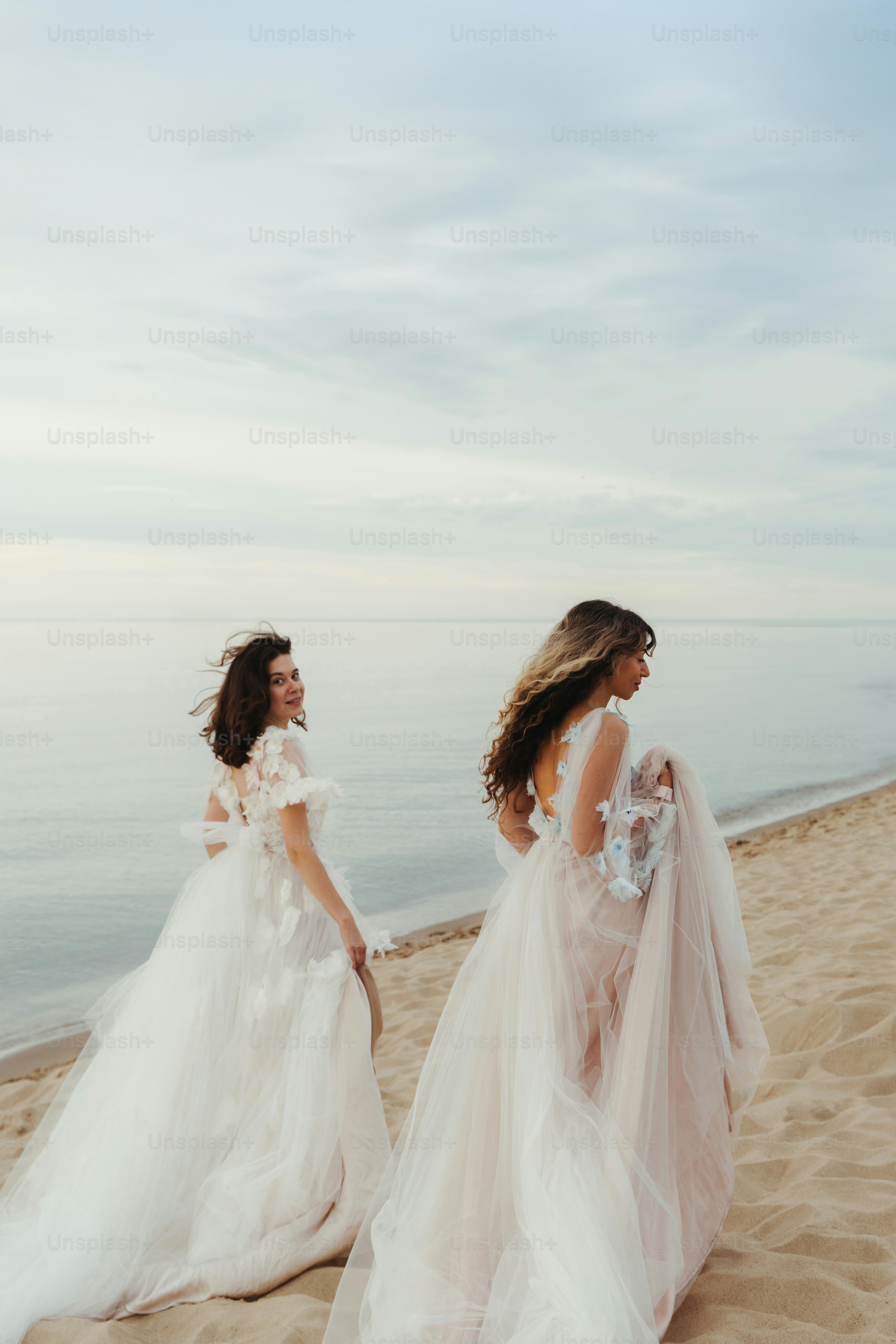 Two women in white dresses holding hands photo – Love Image on Unsplash