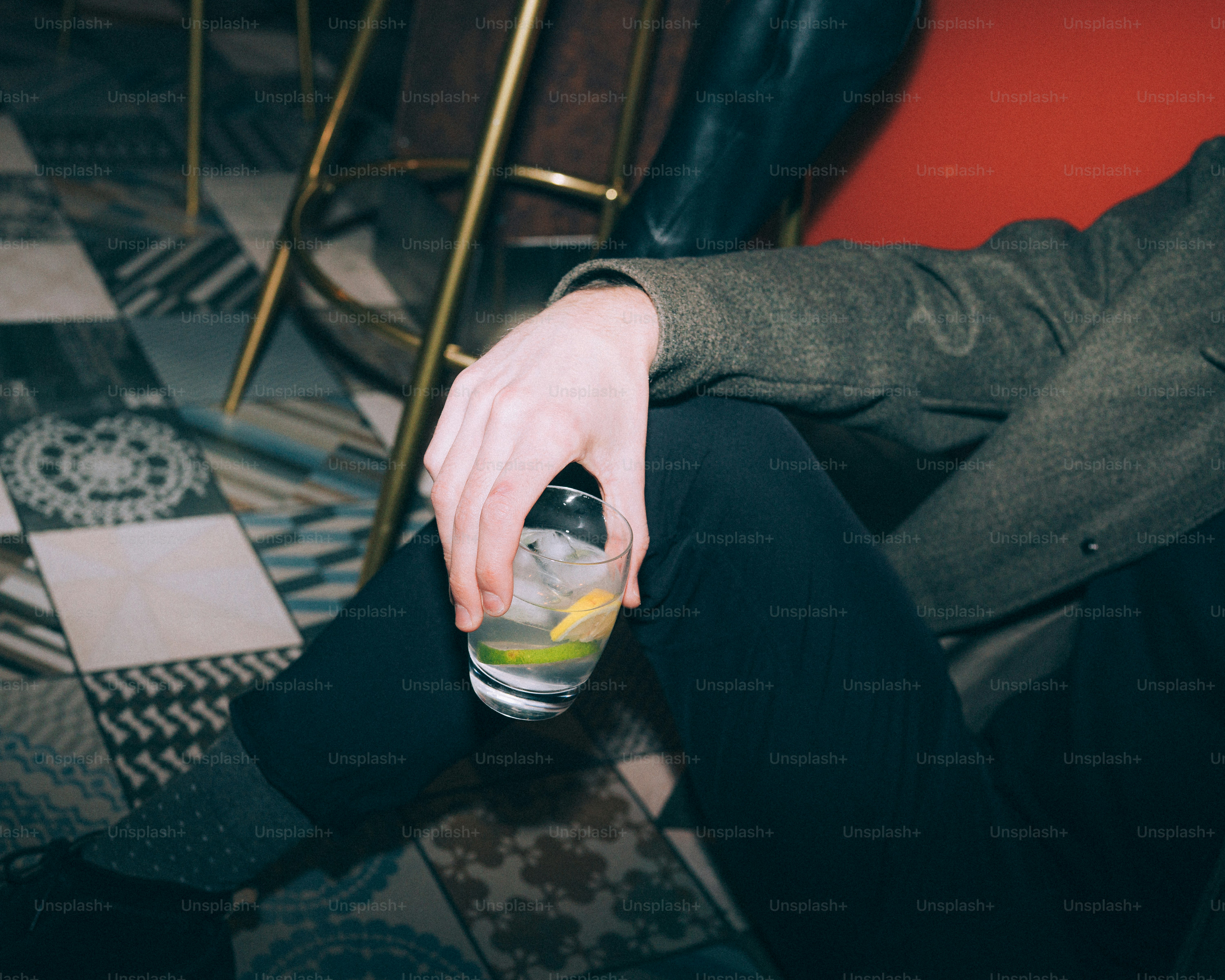 Person holding a drink with ice and lime