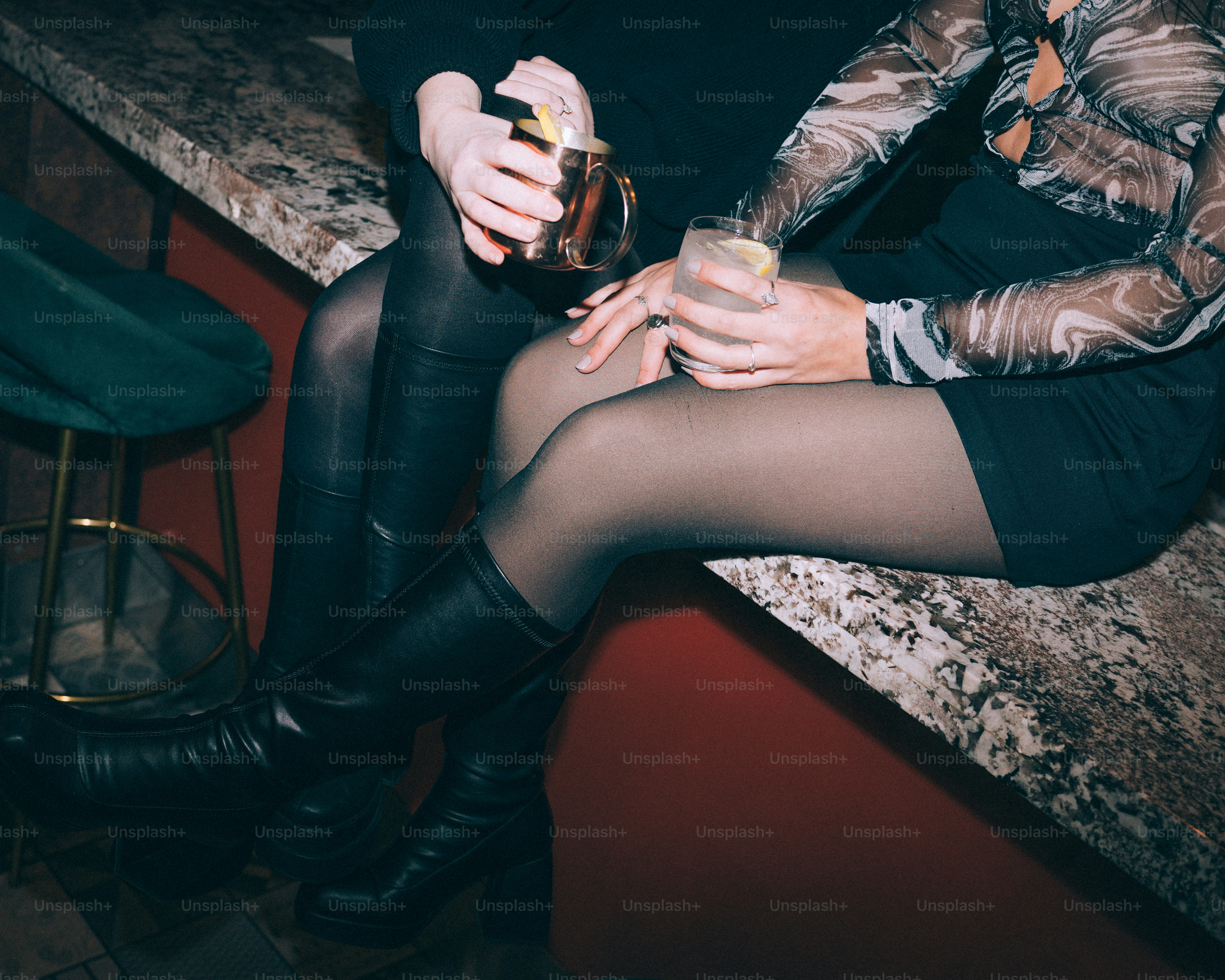 Two people holding drinks at a bar