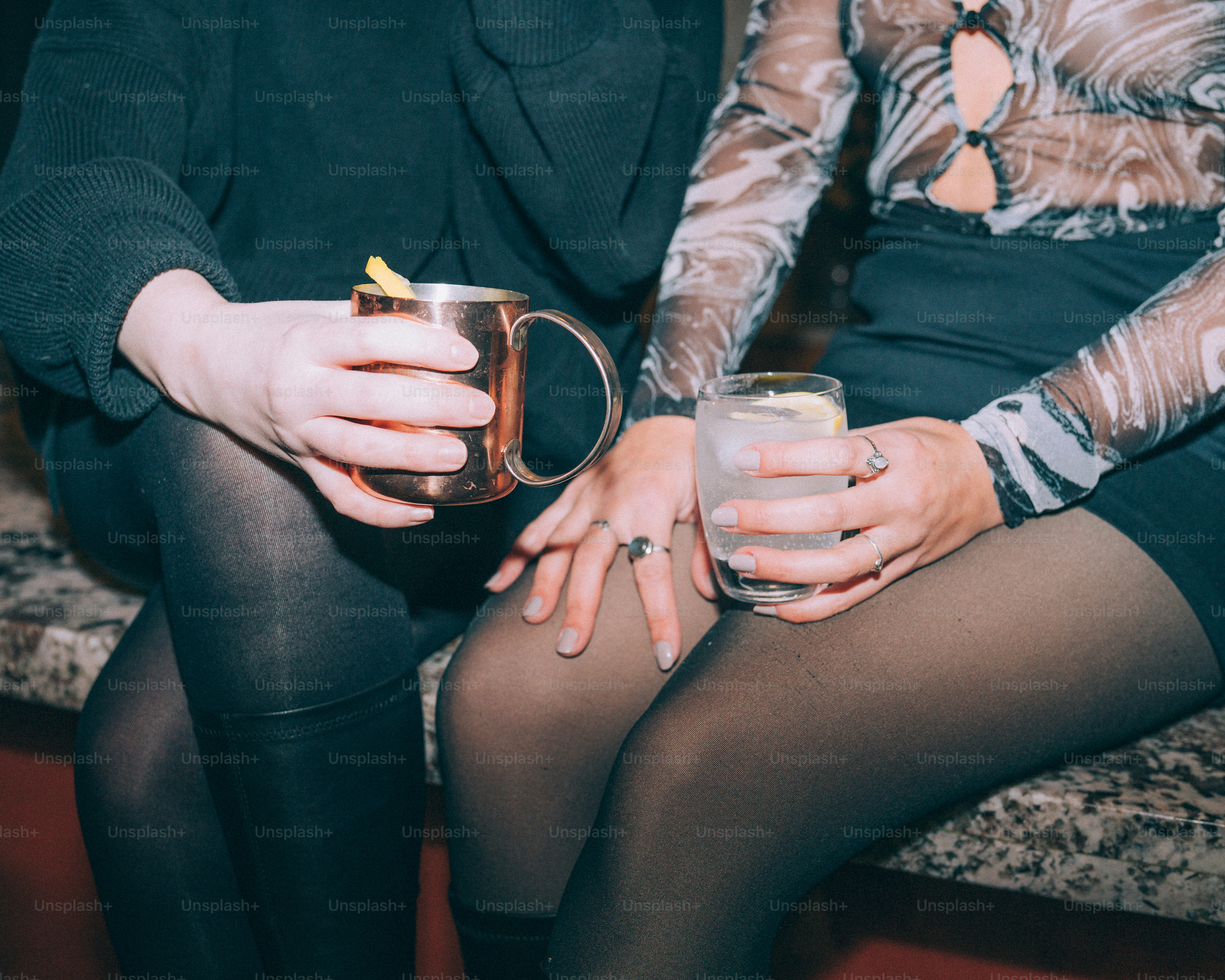 Two people holding drinks at a bar