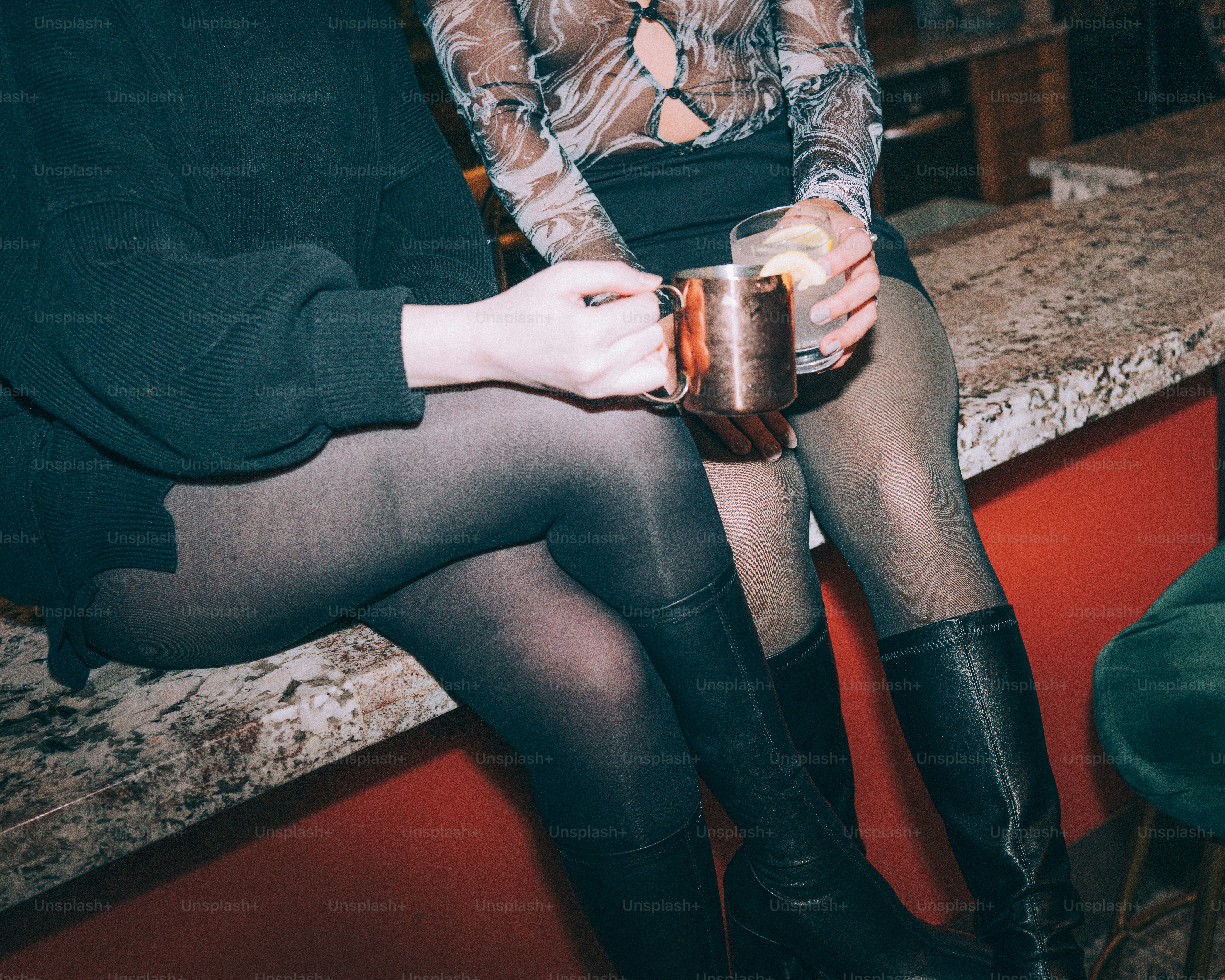 Two people sitting at a bar with drinks.