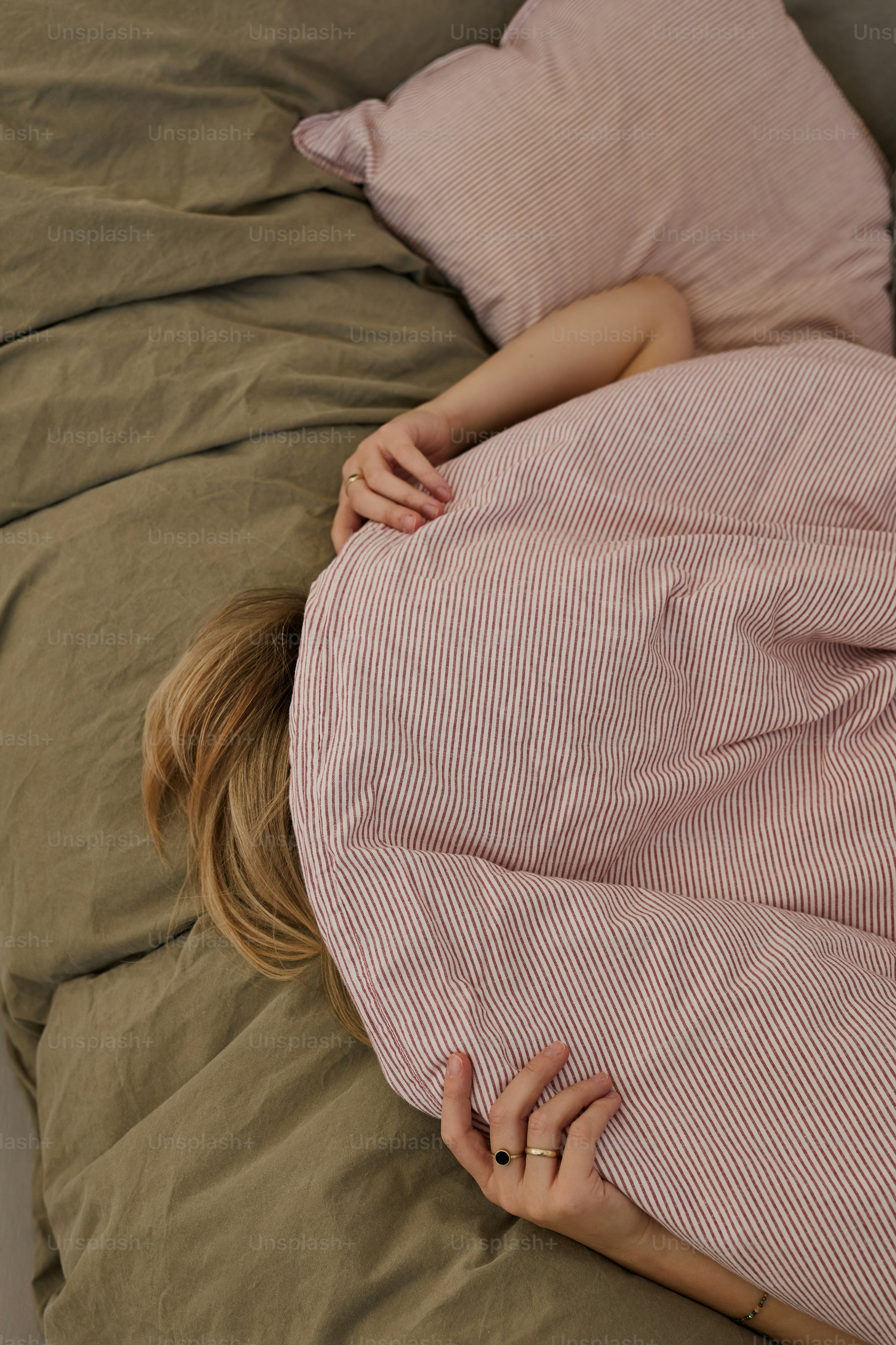 Person hiding under a striped blanket on a bed. photo – Cosy Image on ...