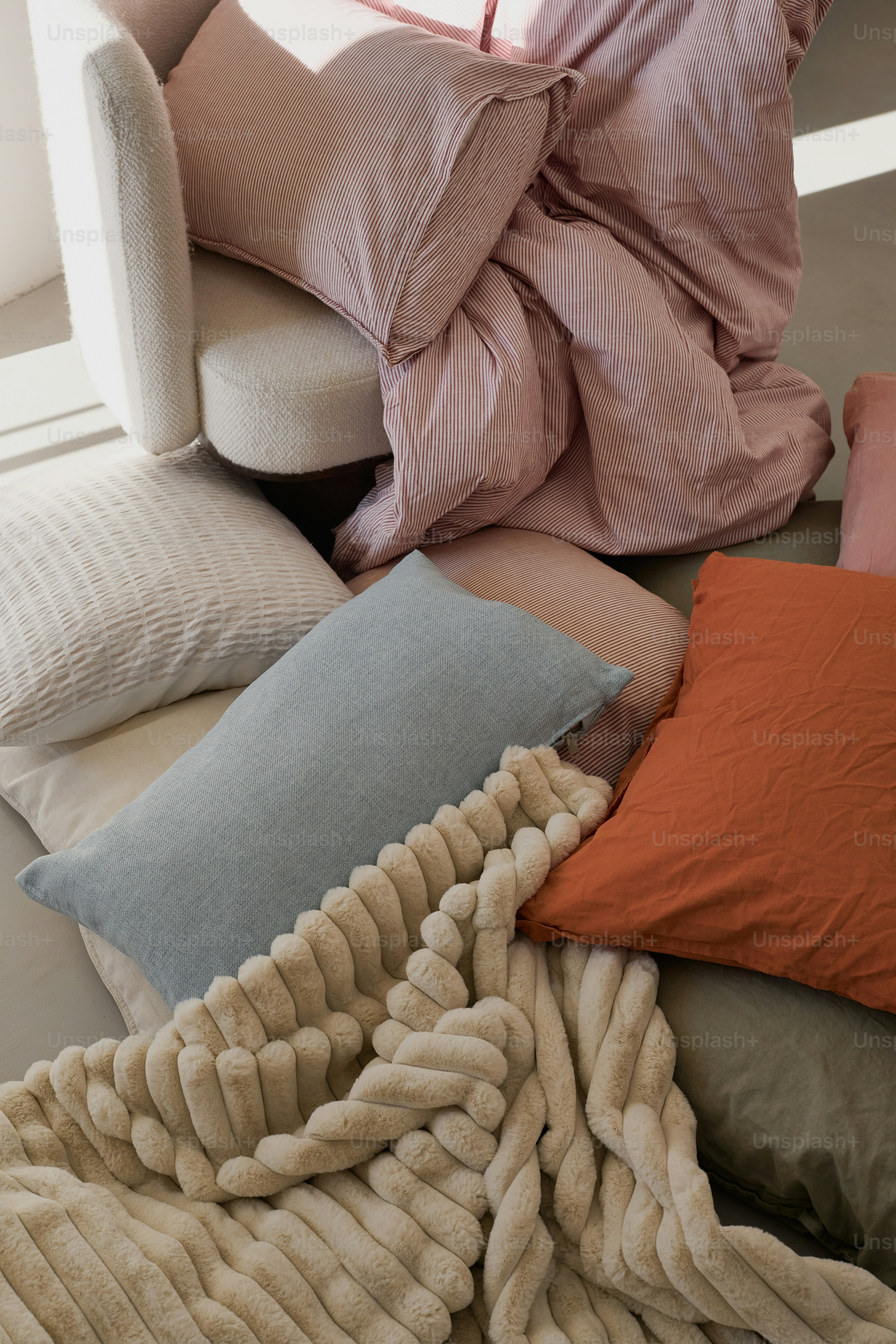 Ropa de cama suave y almohadas dispuestas en el suelo.