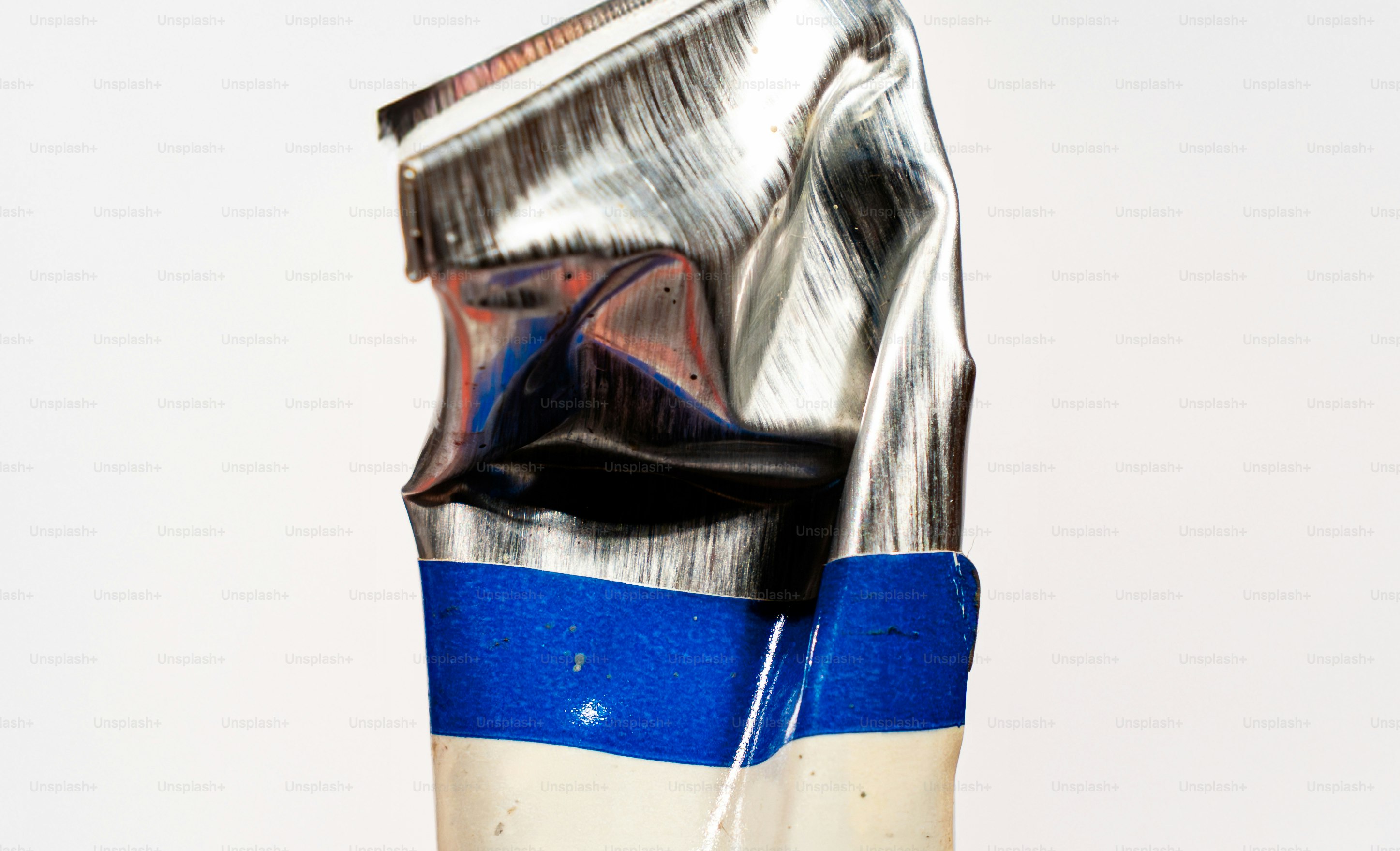 A crushed tube of paint with blue and white